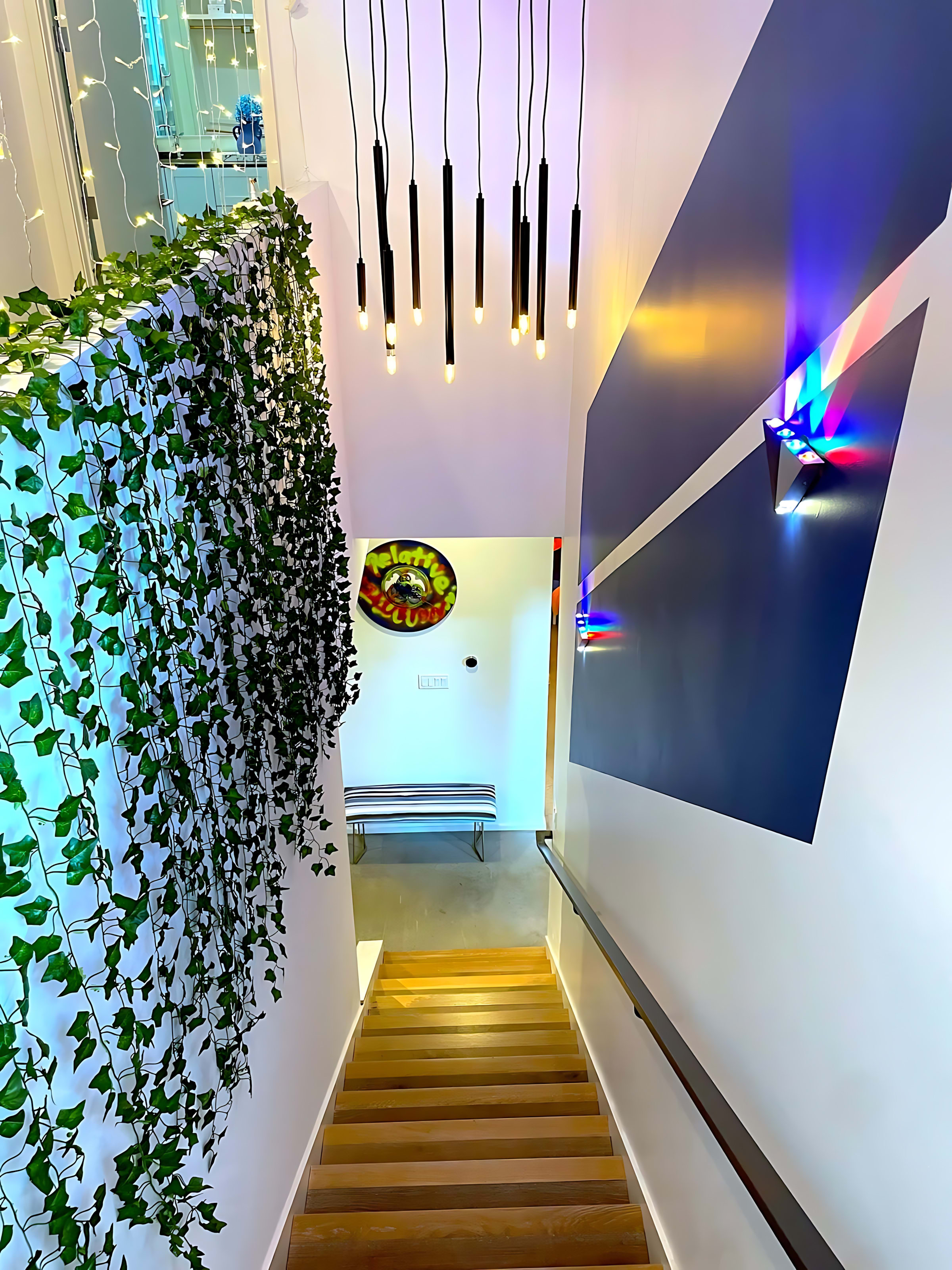 Modern Staircase With Vibrant Lighting And Greenery Accent Wall