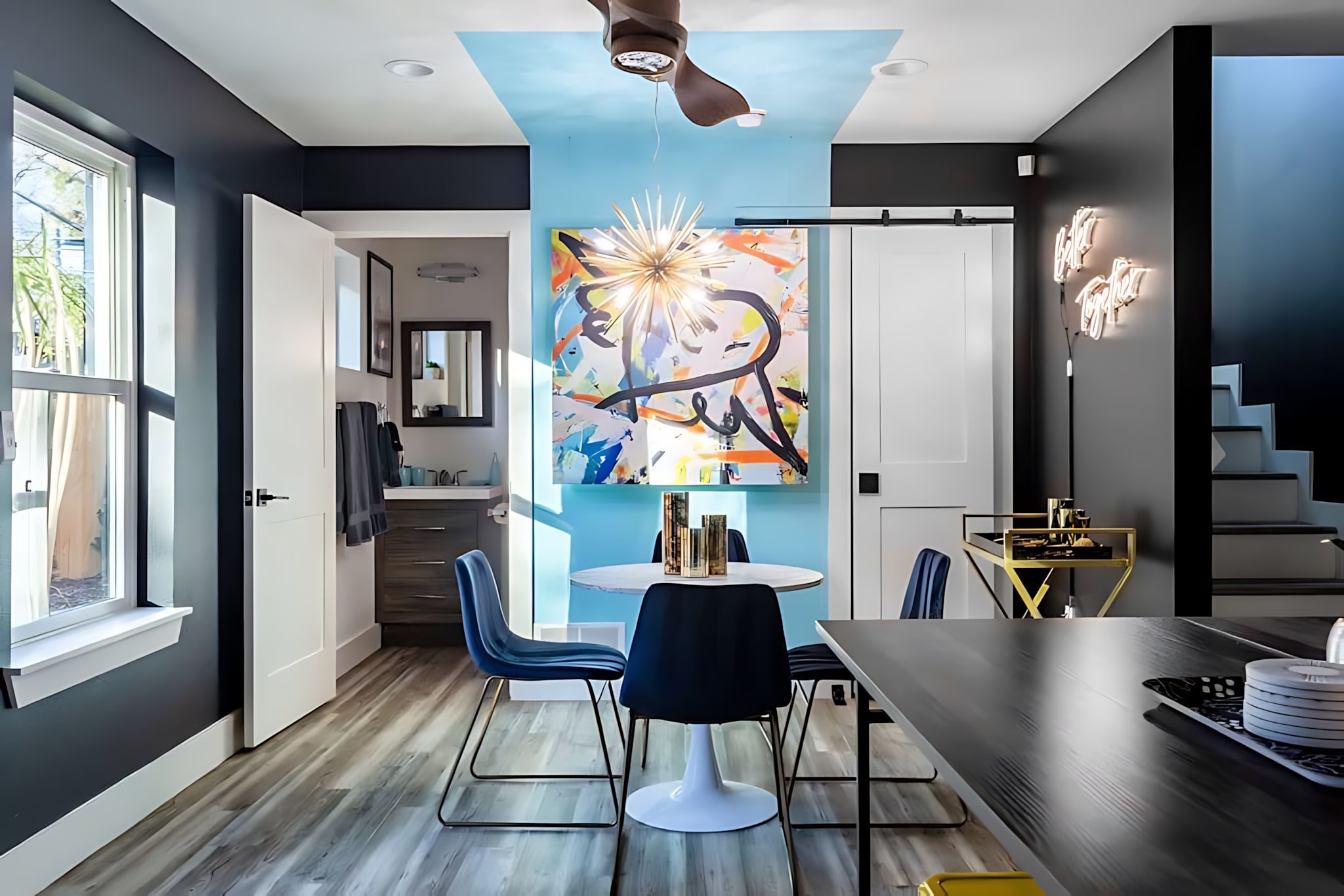 Cozy Dining Area For Four With Artistic Wall Decor And A Bright Lighting Fixture