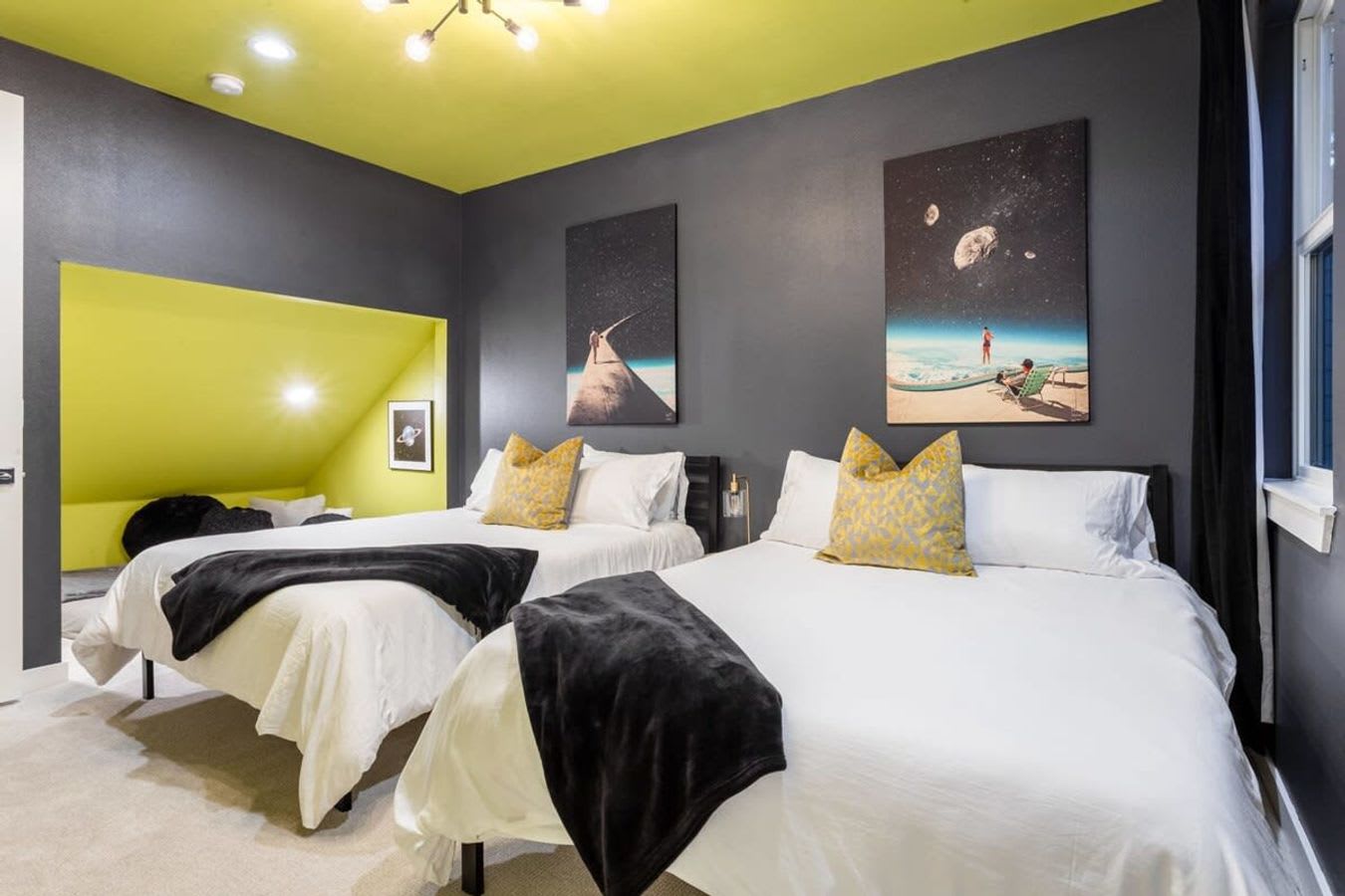 Two Queen Beds With A Pop Of Color And Space-Themed Art