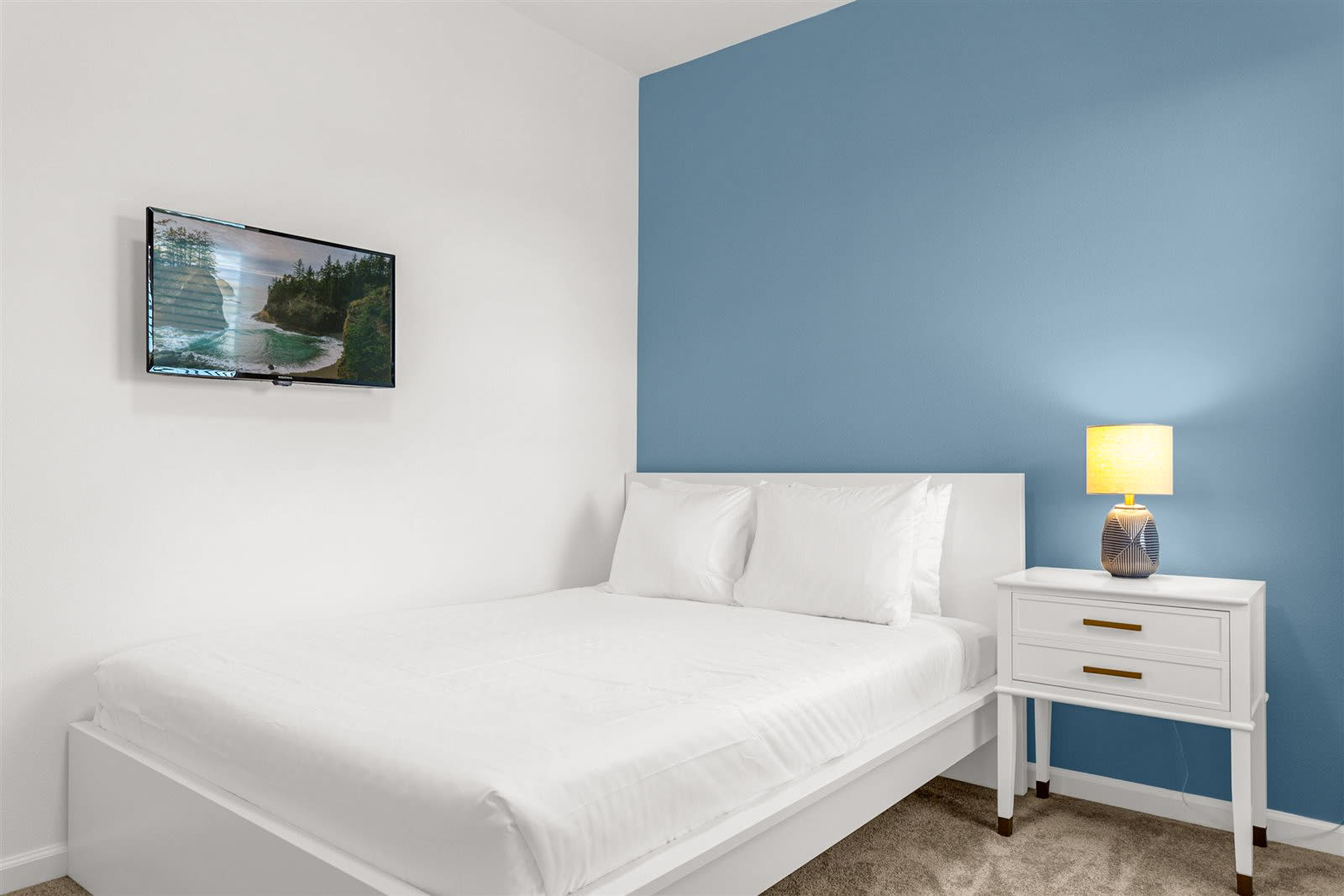 Queen Bedroom With A Vibrant Blue Accent Wall And Smart TV