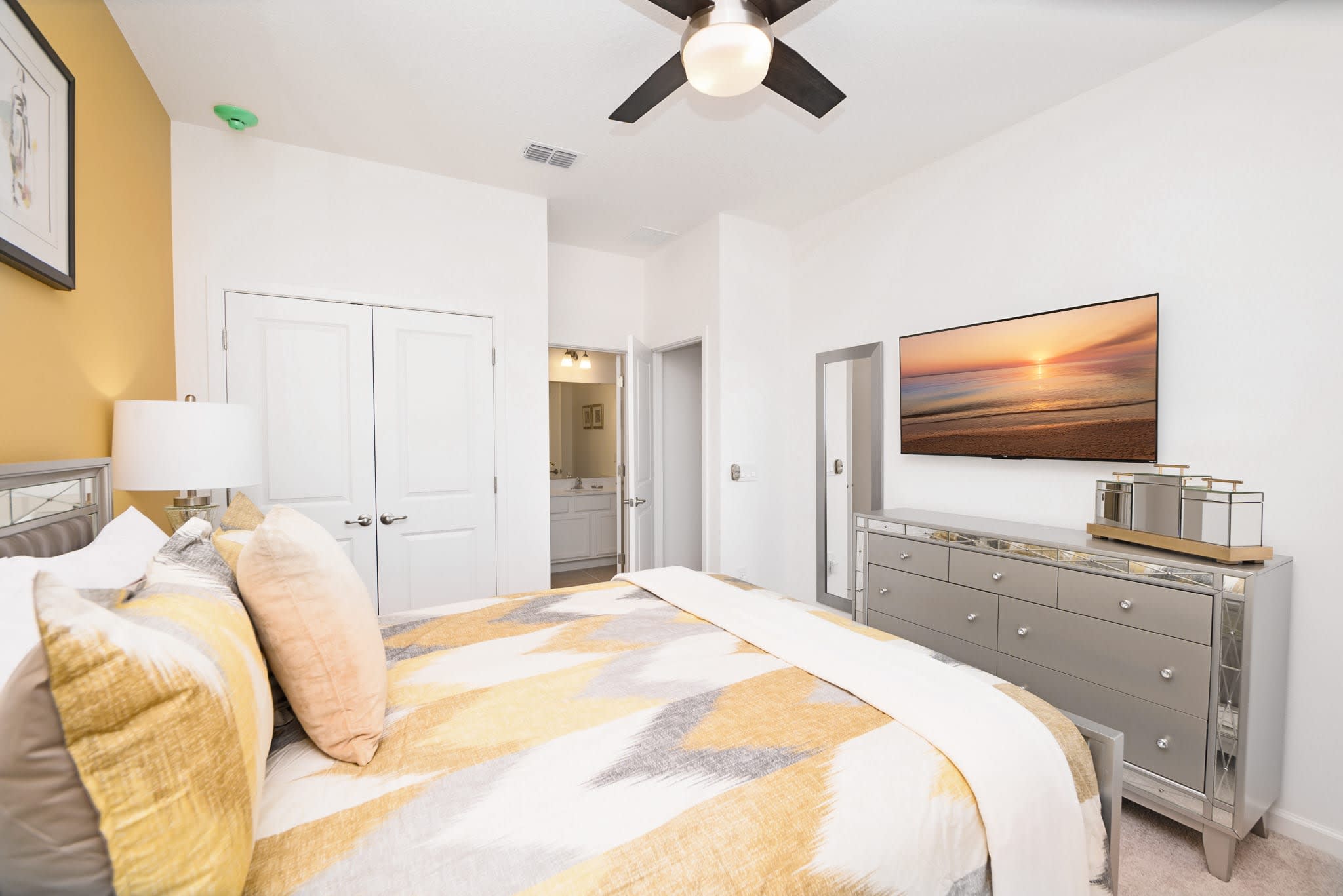 Bright Bedroom Featuring A Queen-Sized Bed And Vibrant Yellow Accents
