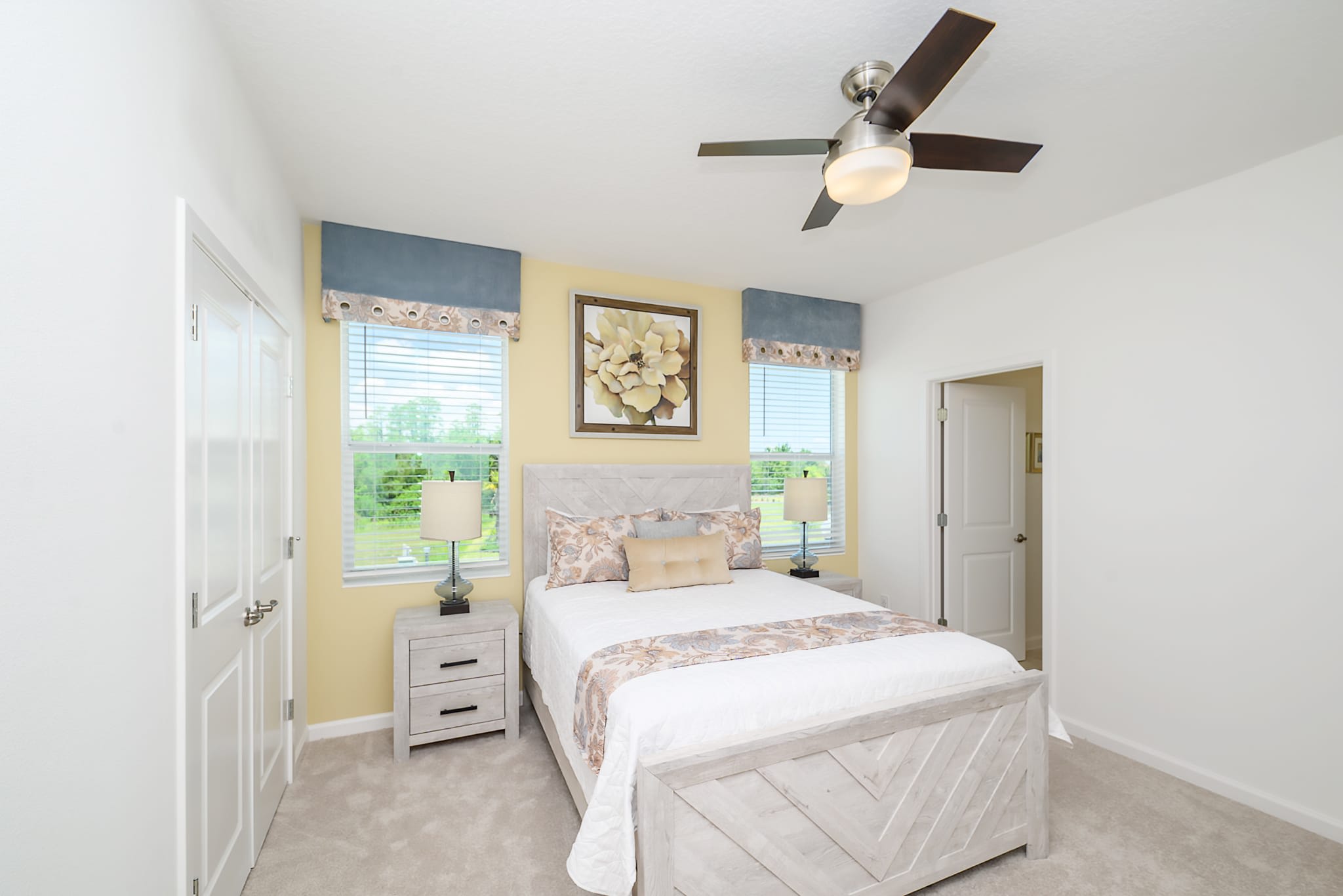 Bright Bedroom Featuring A Queen-Sized Bed And Floral Decor Accents