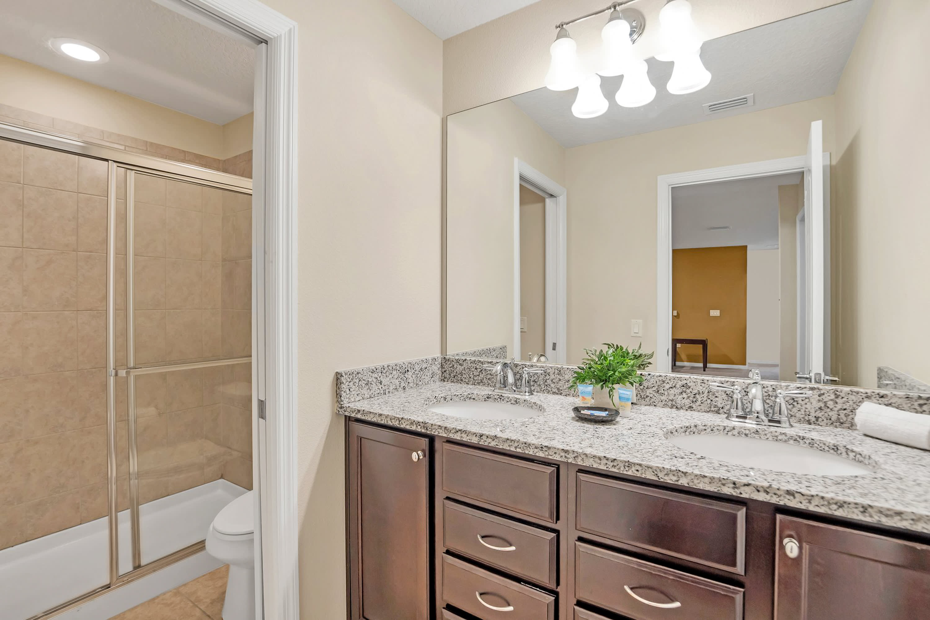Sleek Bathroom With Granite Countertops And Glass Shower