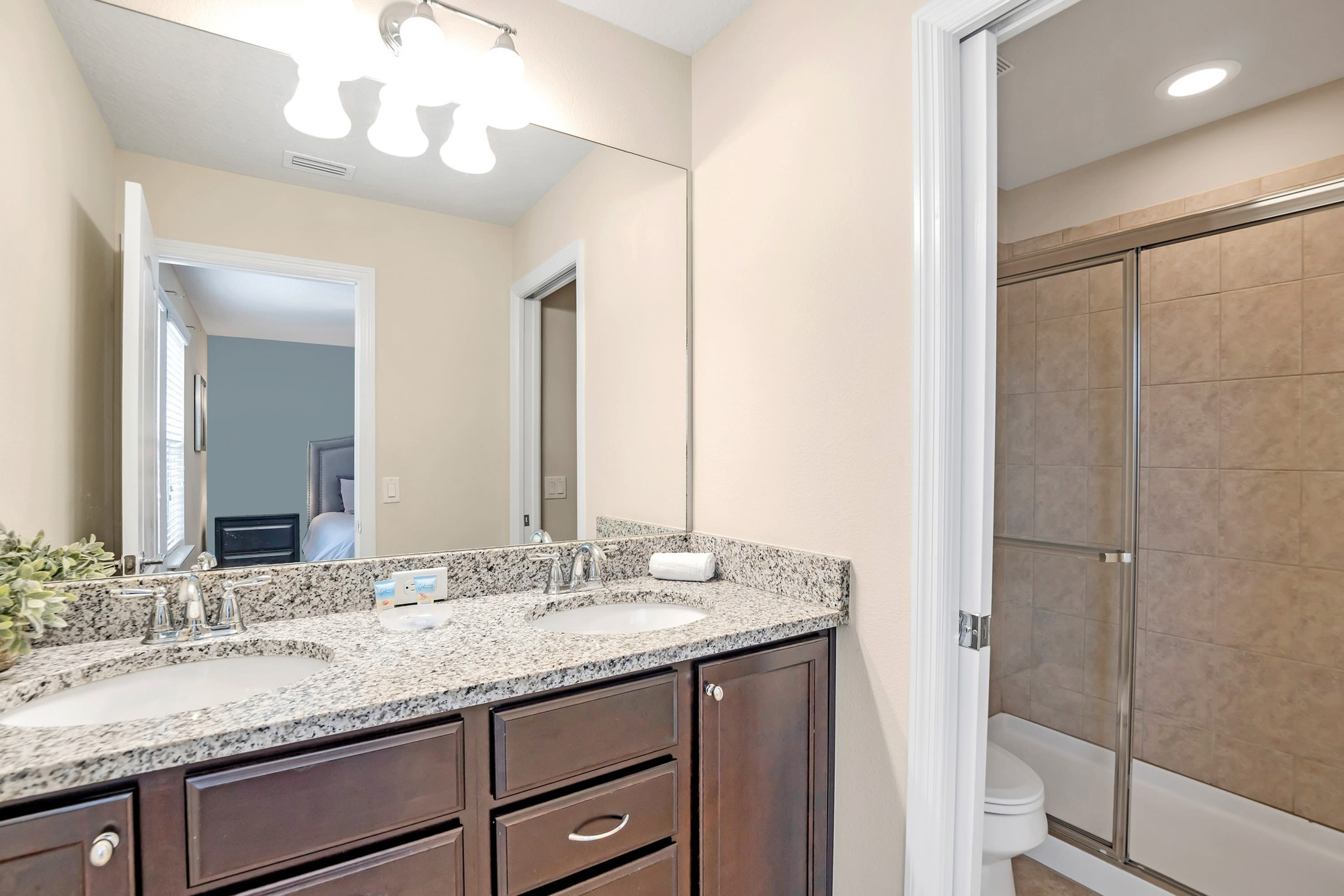 Sleek Bathroom With Granite Countertops And Glass Shower