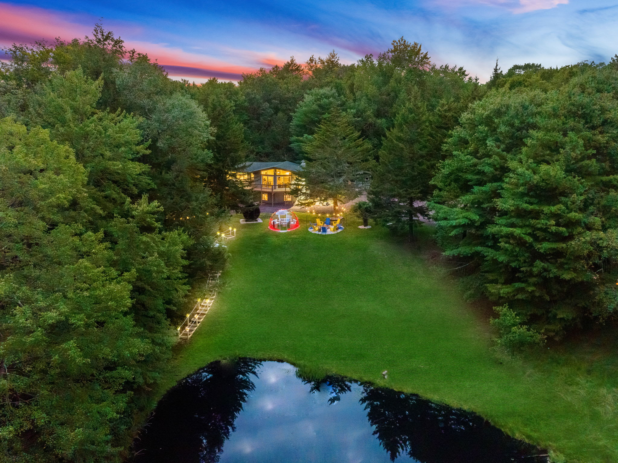 Experience ultimate serenity with this scenic property, featuring a lush lawn, private pond, and dreamy sunset views.
