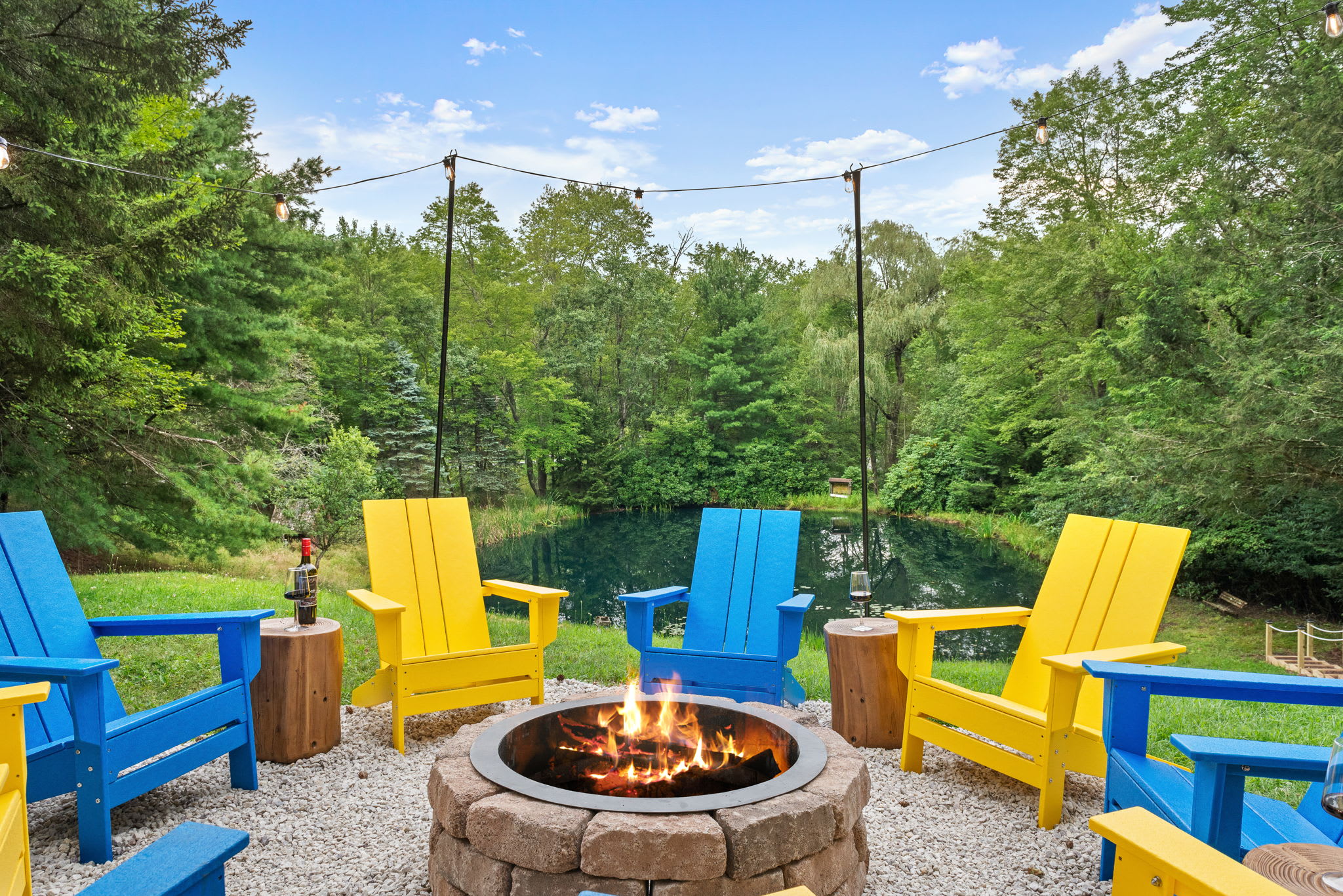 Surrounded by colorful Adirondack chairs, this fire pit is the ultimate spot for cozy nights and peaceful mornings overlooking the water.