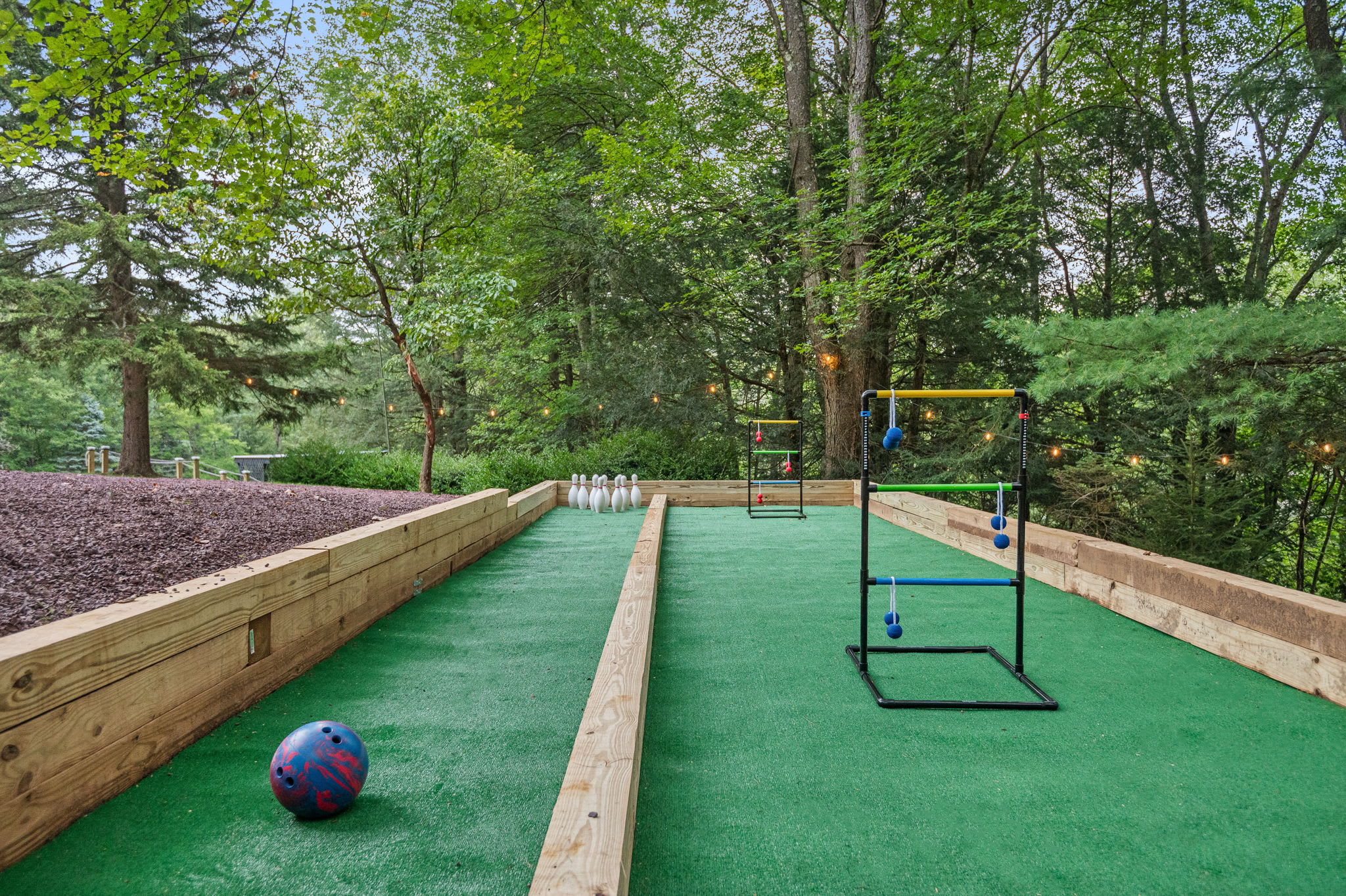 Get competitive with classic backyard games like bowling and ladder toss, all set within a lush green forest.
