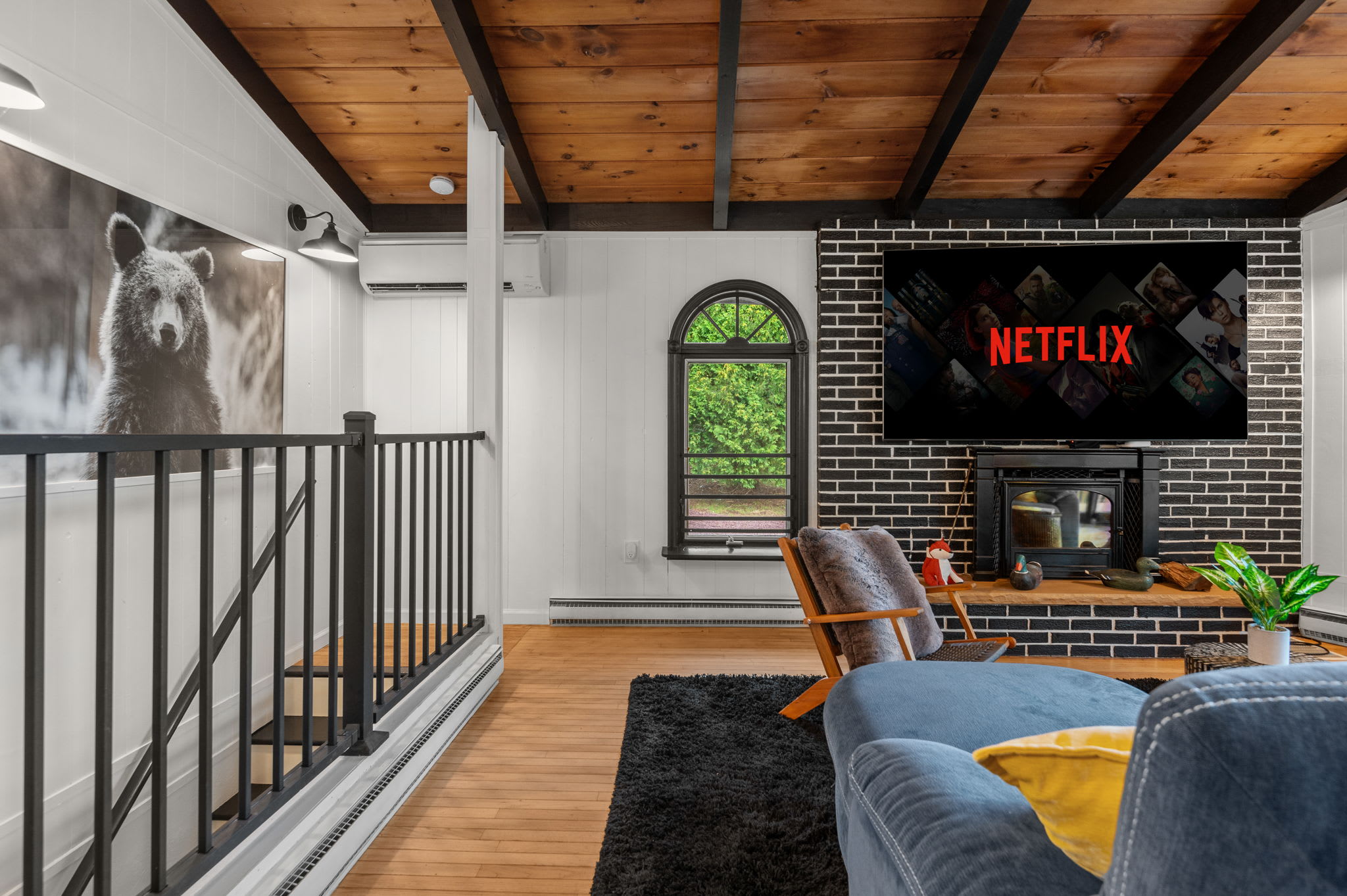 Gather in this warm and inviting living space, where rustic charm meets modern entertainment. The perfect spot for a Netflix night by the fire.