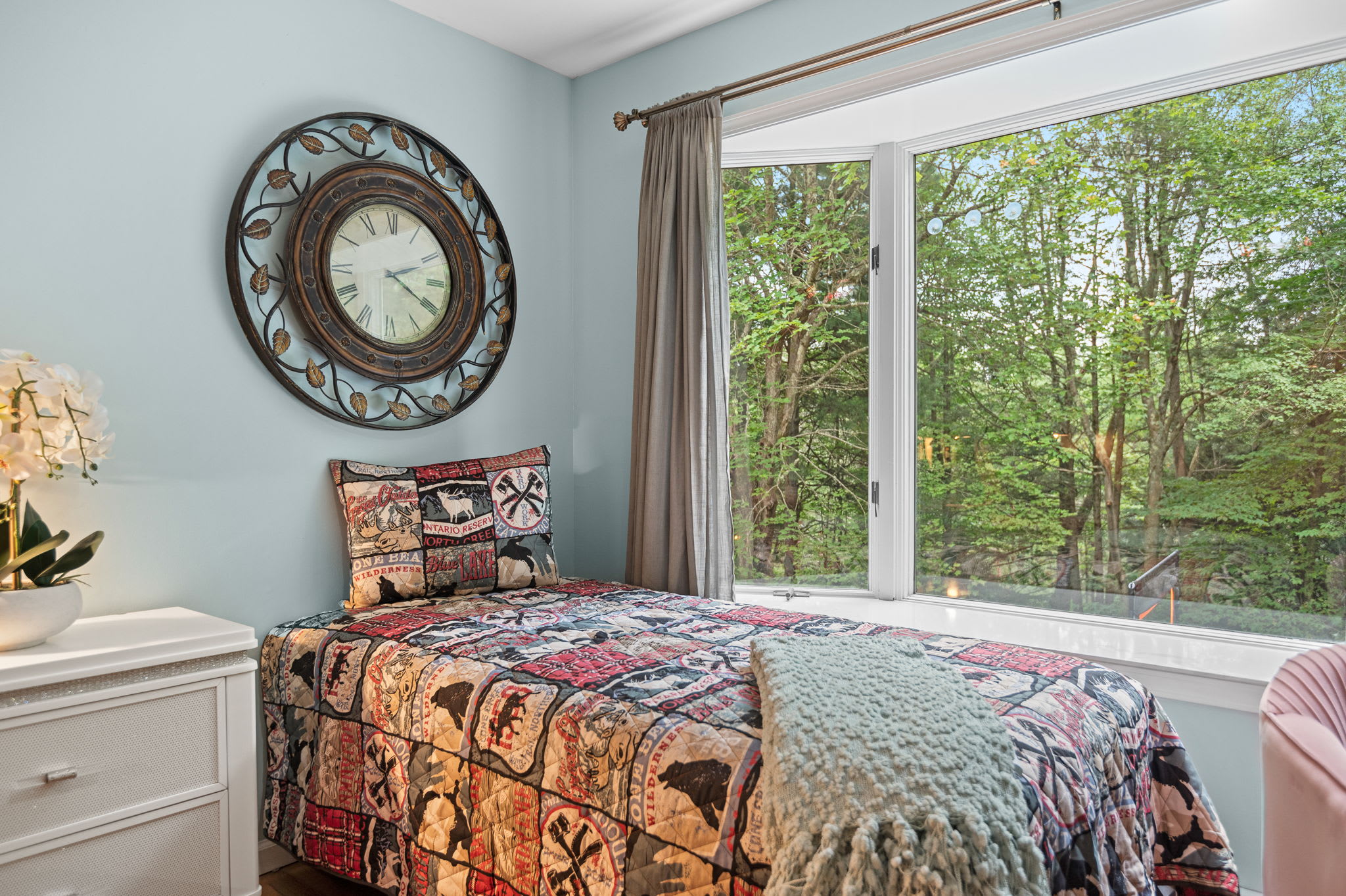 This charming single bed offers a cozy retreat with a stunning view of the lush greenery outside, perfect for relaxation or reading a book.