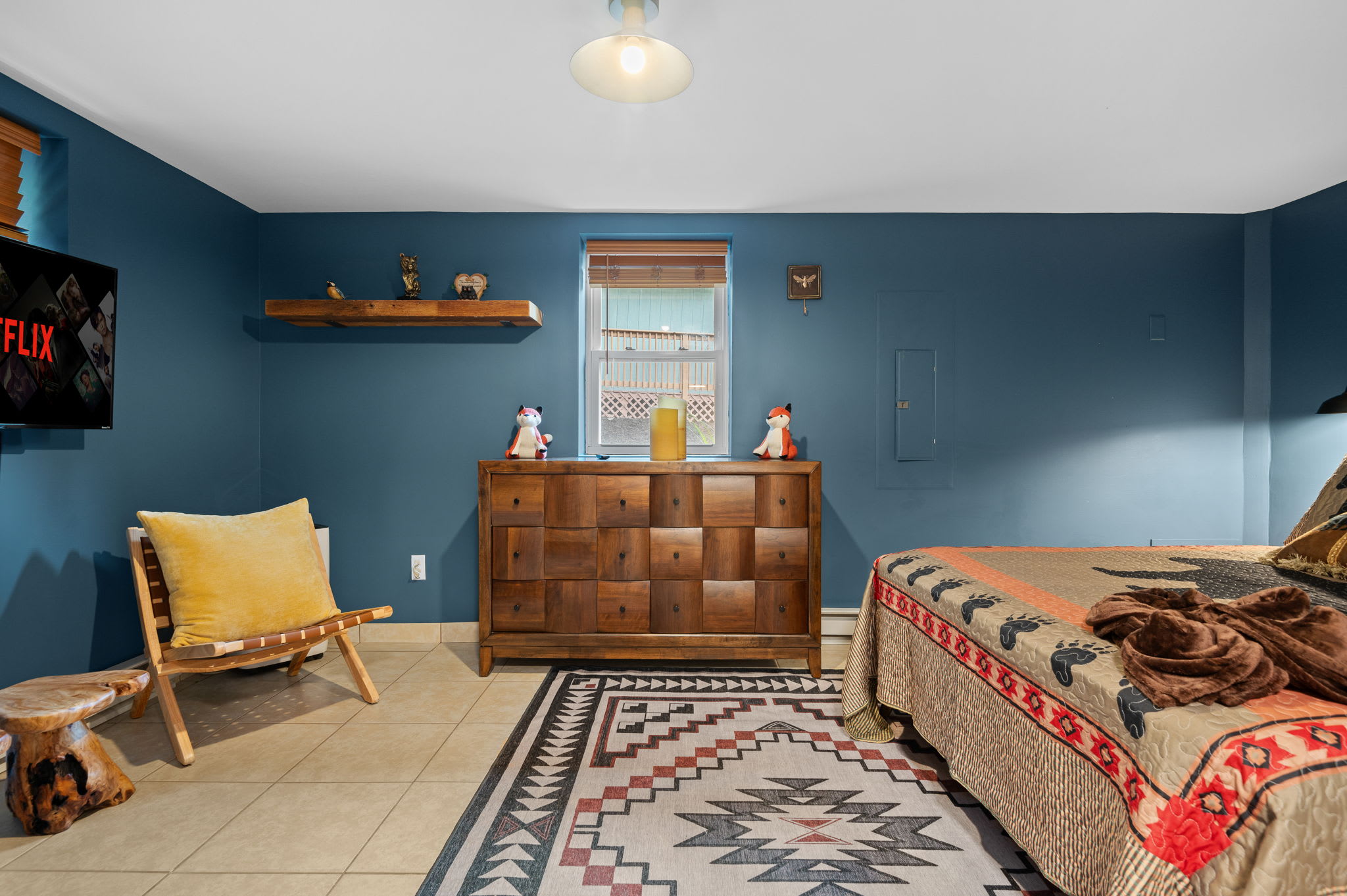 Drift into a peaceful sleep in this cozy, cabin-inspired bedroom. Warm textures and rich hues create a space that feels both inviting and luxurious.