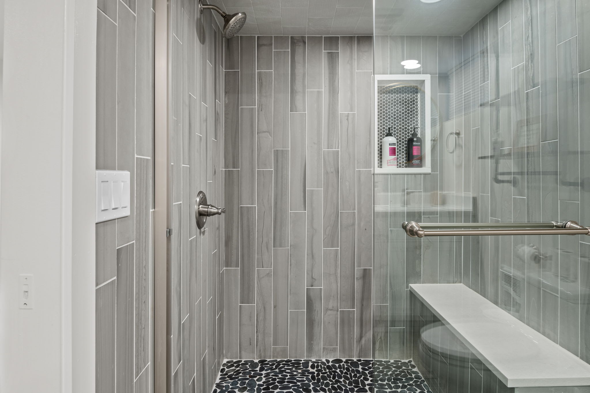 Refresh yourself in this beautifully designed shower with sleek tiles, a rainfall showerhead, and spa-like vibes.