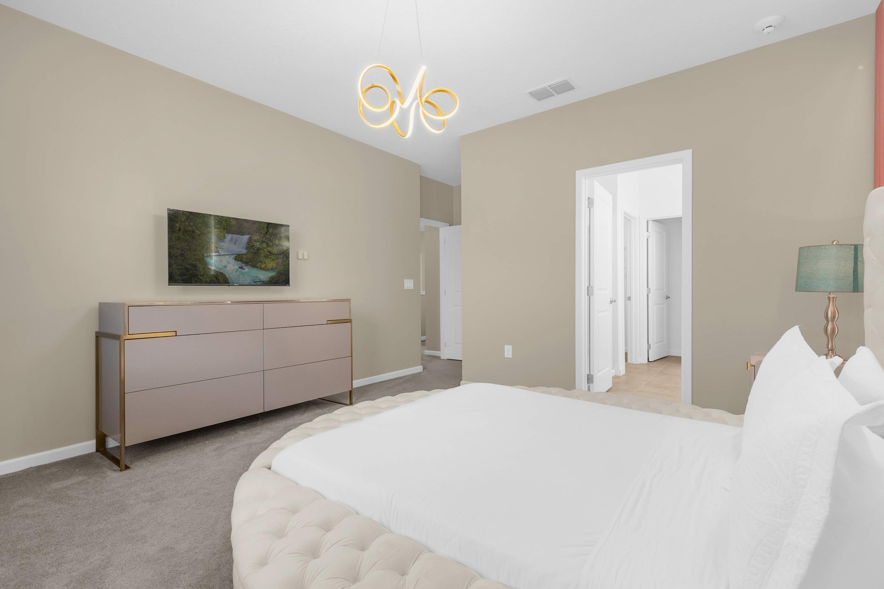 Elegant Bedroom With A Queen Bed, Colorful Wall Decor, And A Smart TV