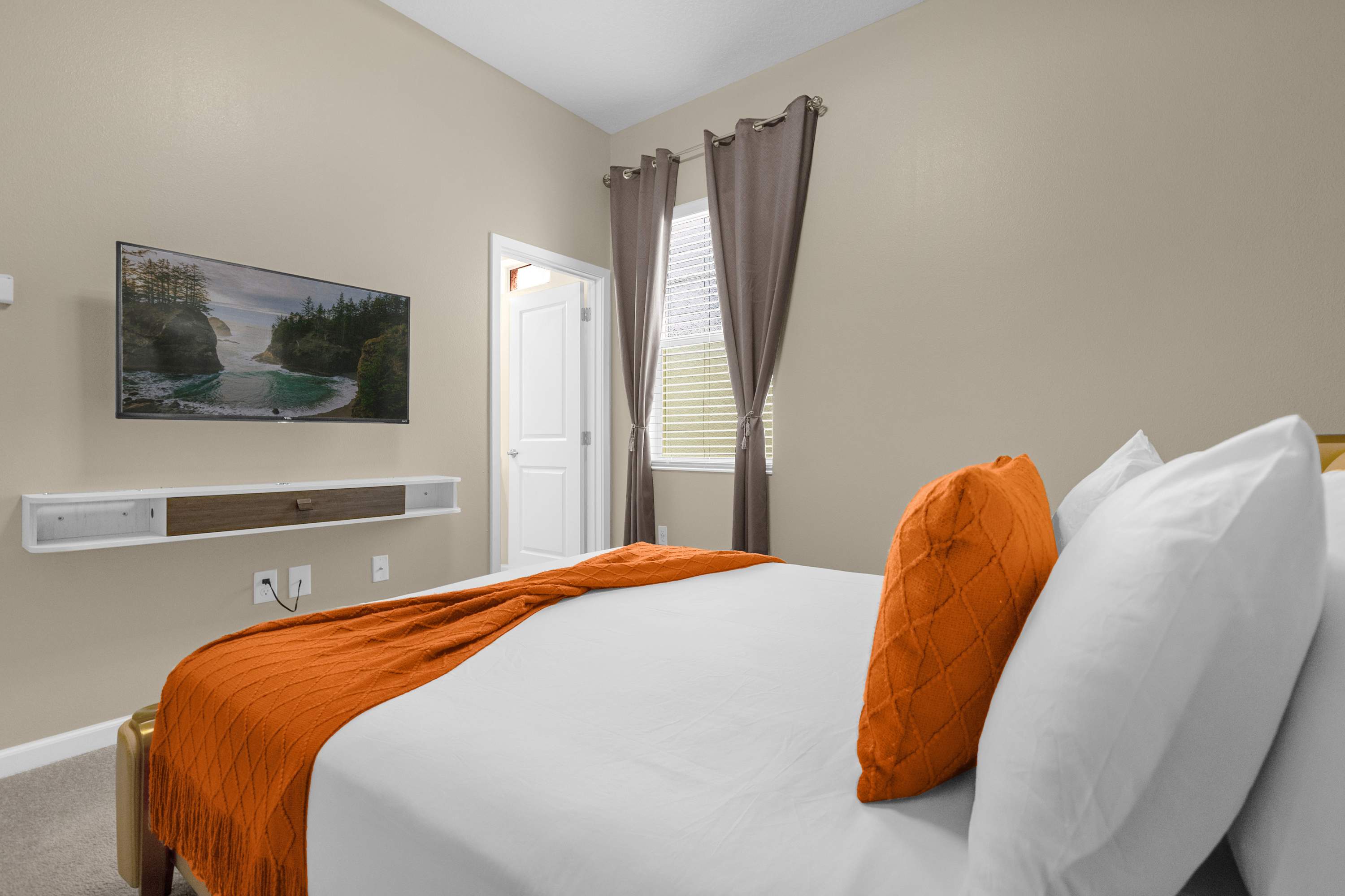 Elegant Bedroom With A Queen Bed, Colorful Wall Decor, And A Smart TV