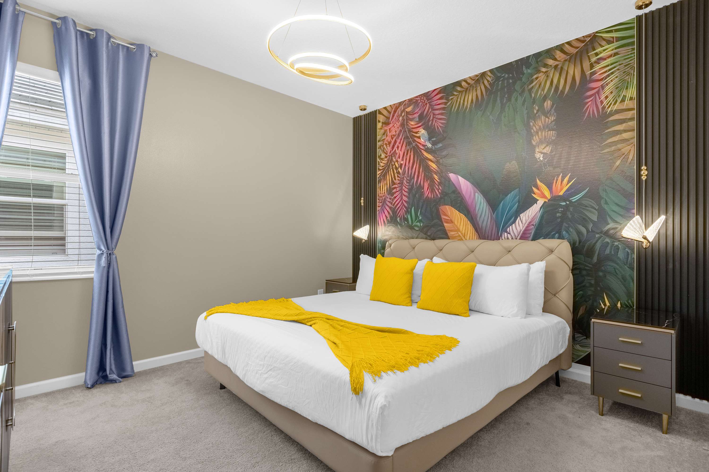 Luxurious Bedroom With A King Bed Featuring Vibrant Wall Art And A Smart TV