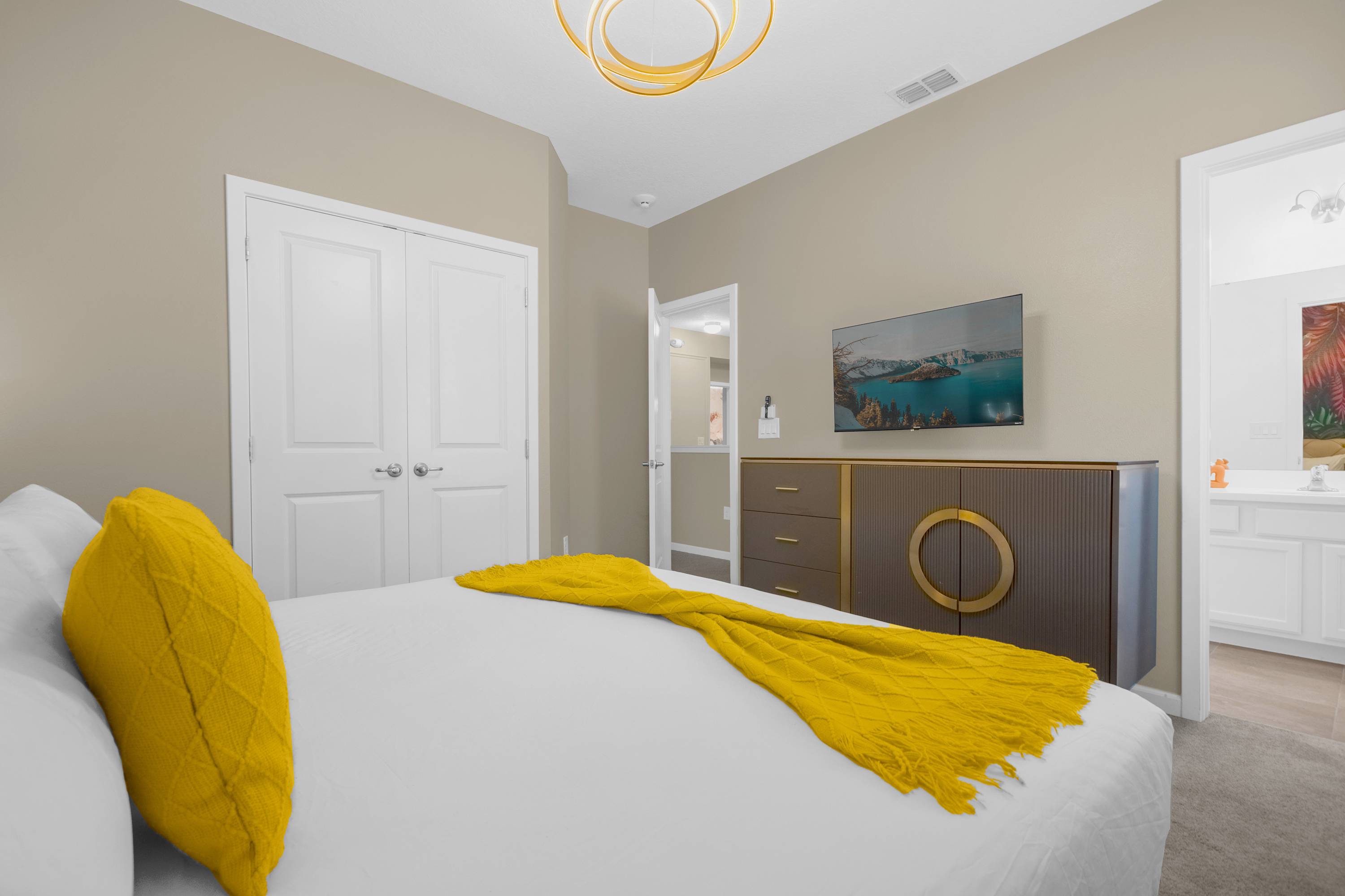 Luxurious Bedroom With A King Bed Featuring Vibrant Wall Art And A Smart TV