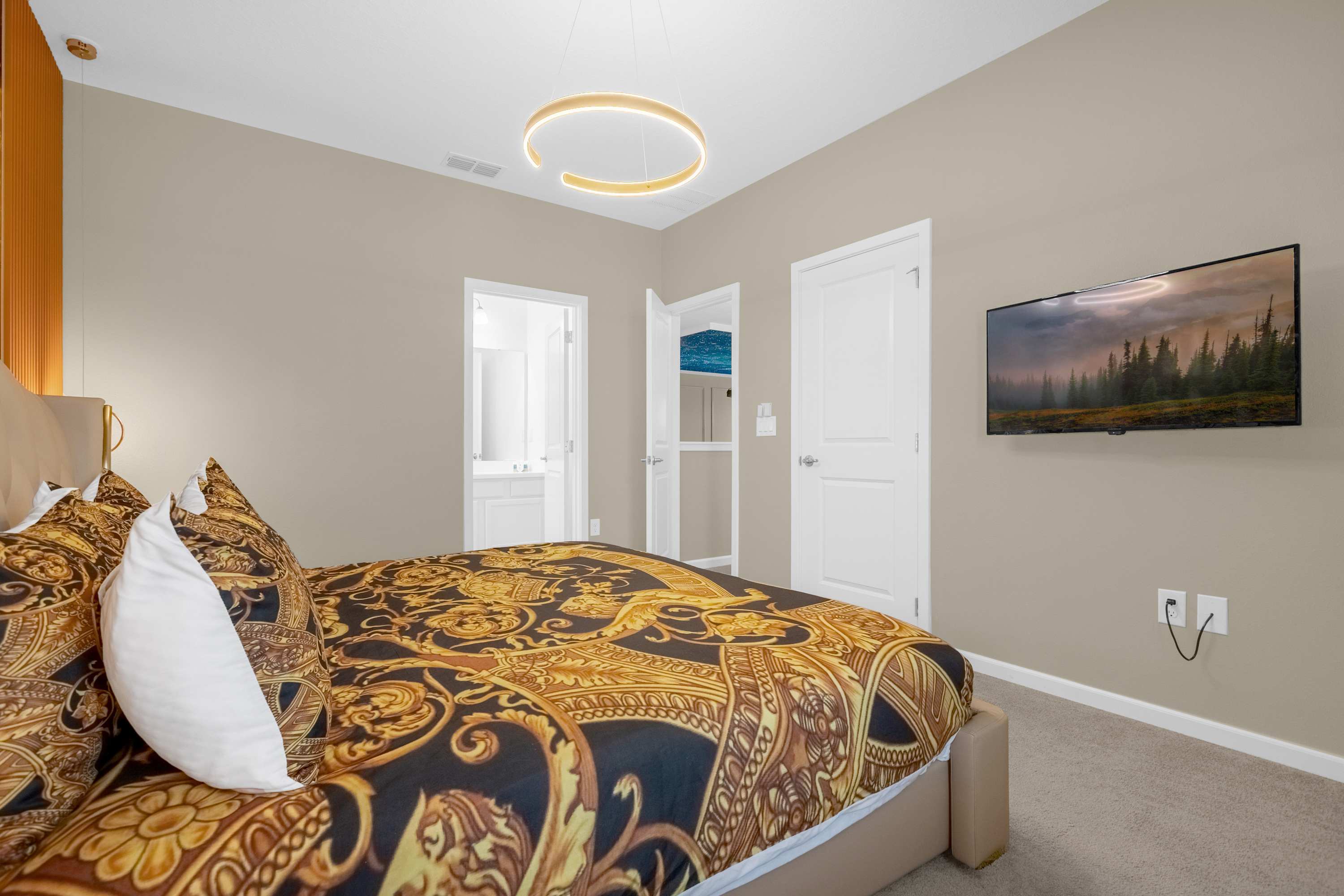 Elegant Bedroom With A Queen Bed, Colorful Wall Decor, And A Smart TV