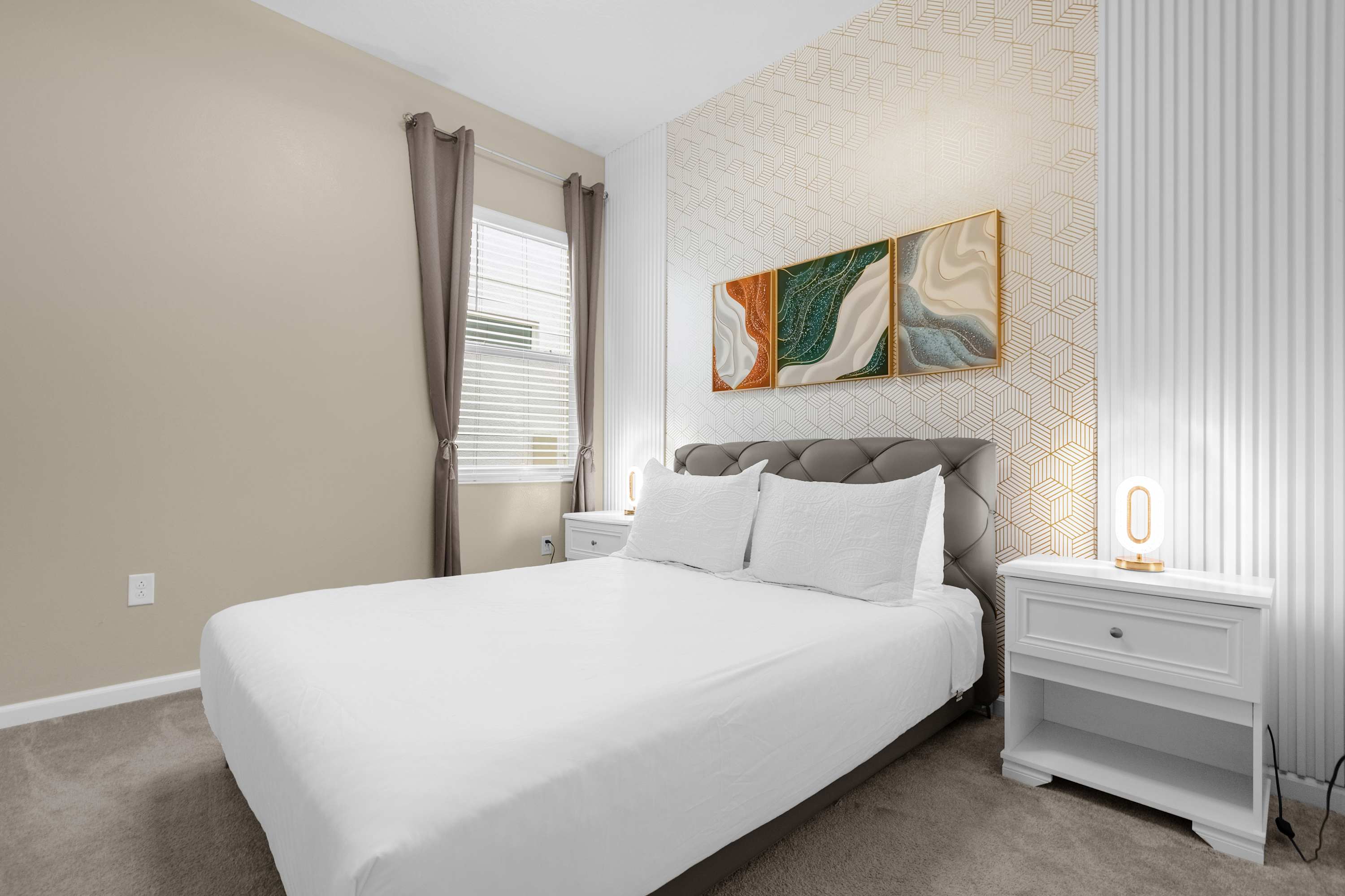 Elegant Bedroom With A Queen Bed, Colorful Wall Decor, And A Smart TV