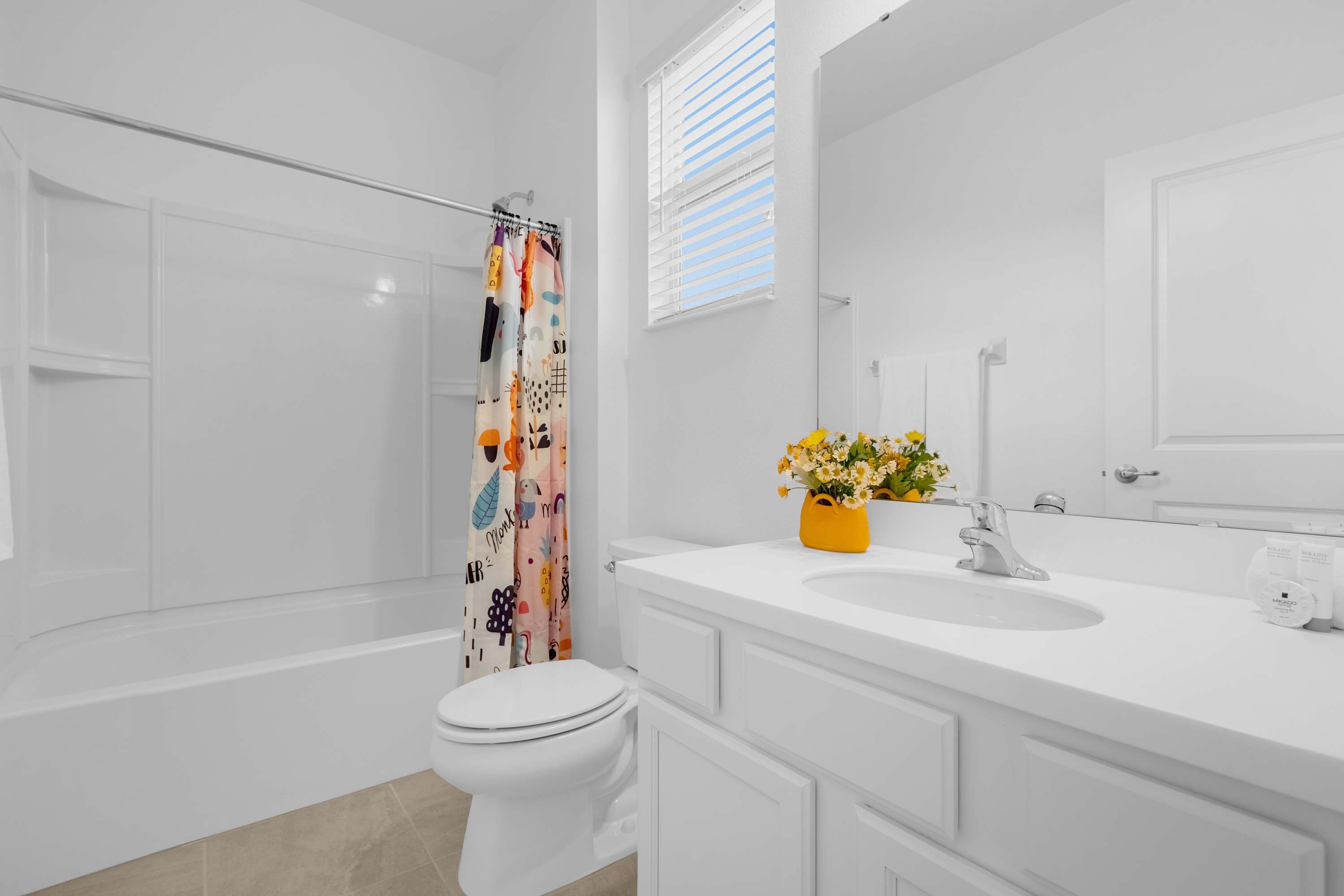 Bright Bathroom With Playful Shower Curtain And Elegant Vanity