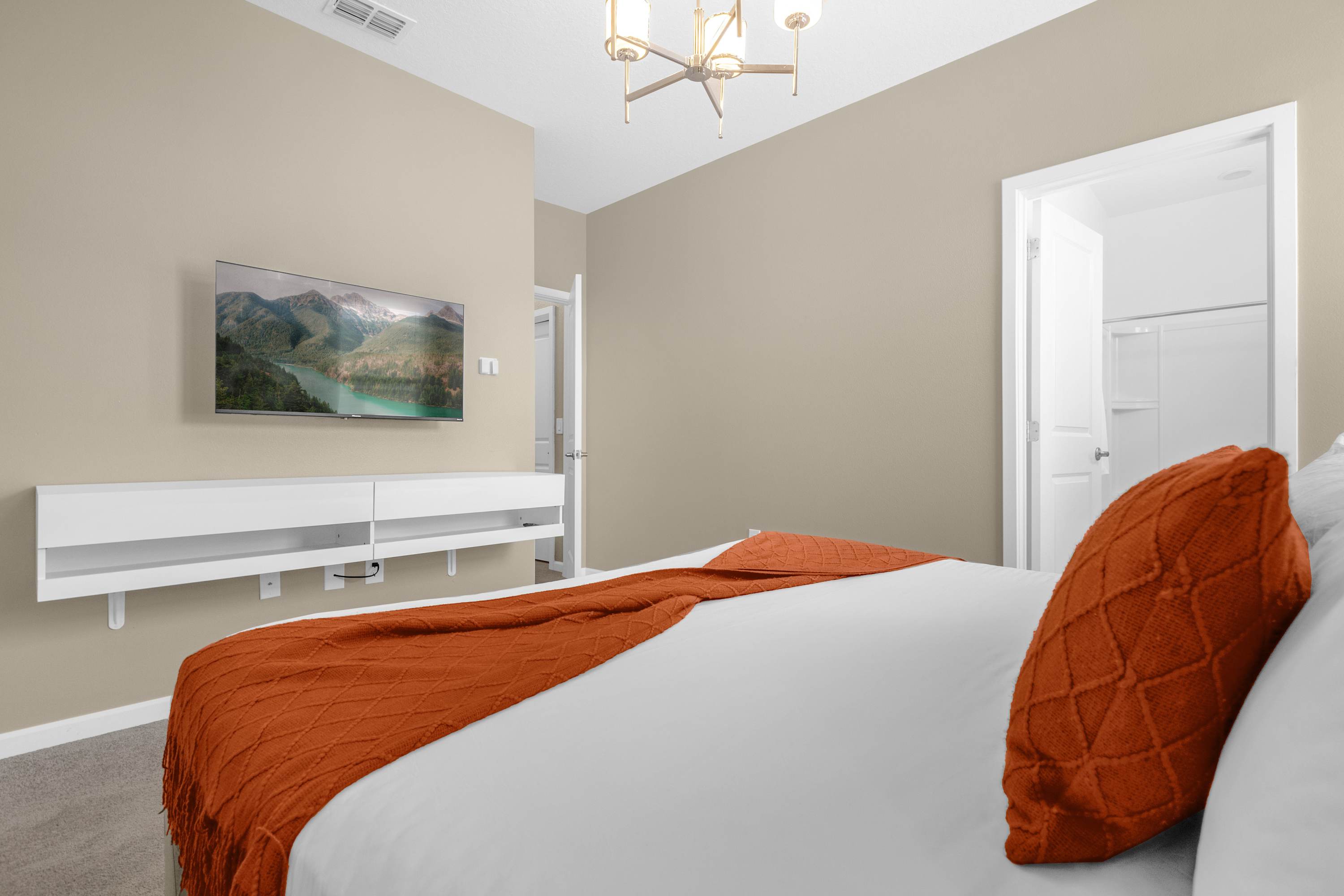 Luxurious Bedroom With A King Bed Featuring Vibrant Wall Art And A Smart TV