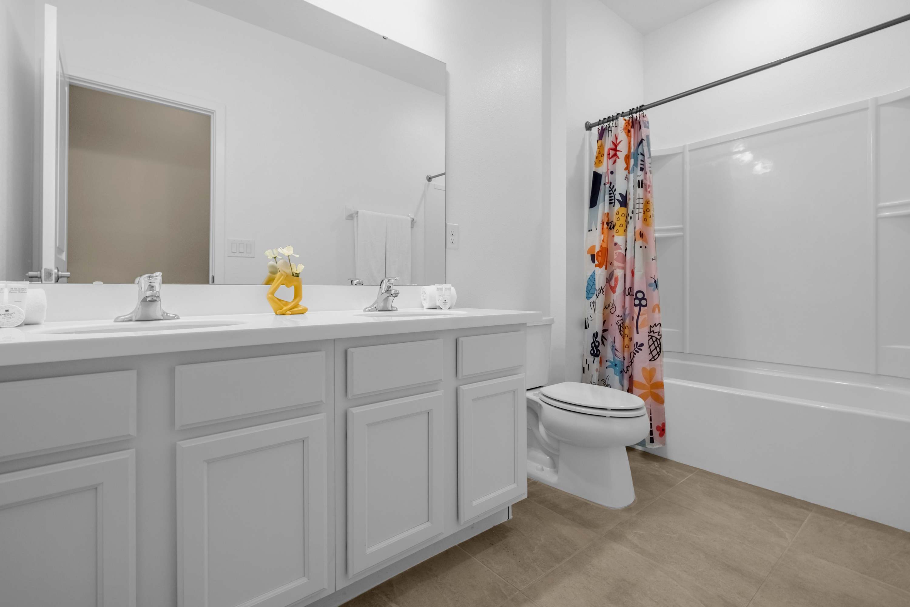 Bright Bathroom With Playful Shower Curtain And Elegant Vanity