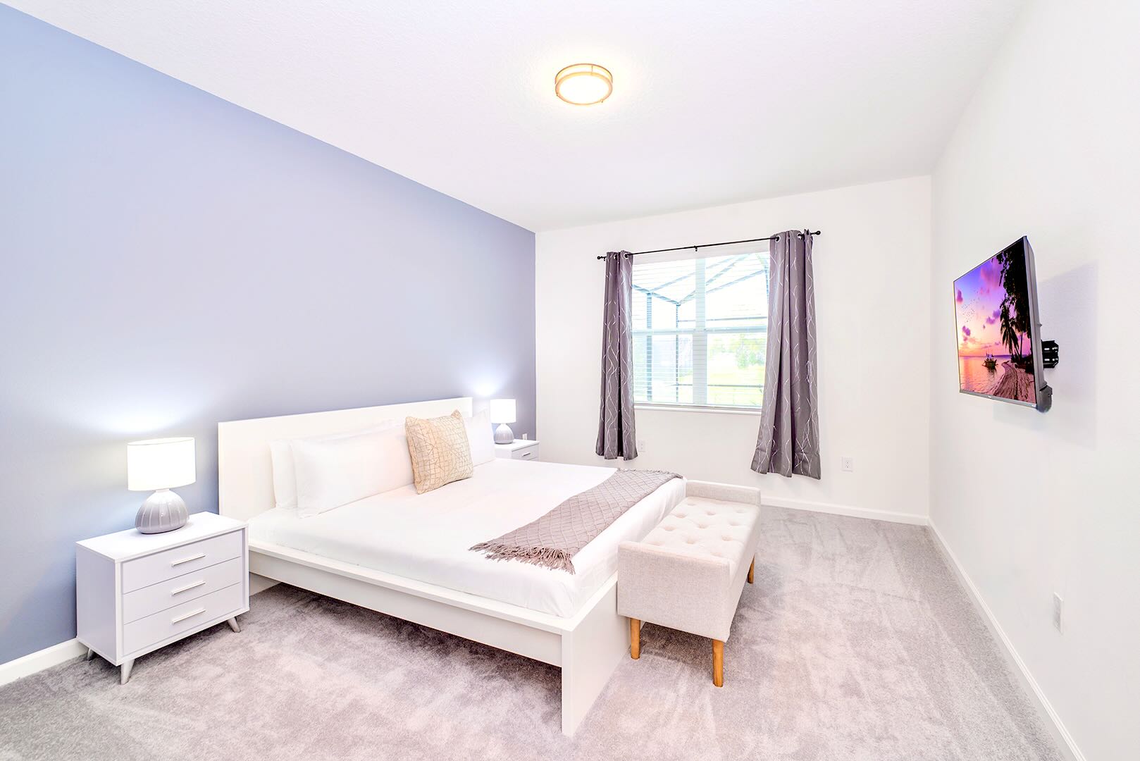 Serene Bedroom With Smart TV And Plenty Of Natural Light