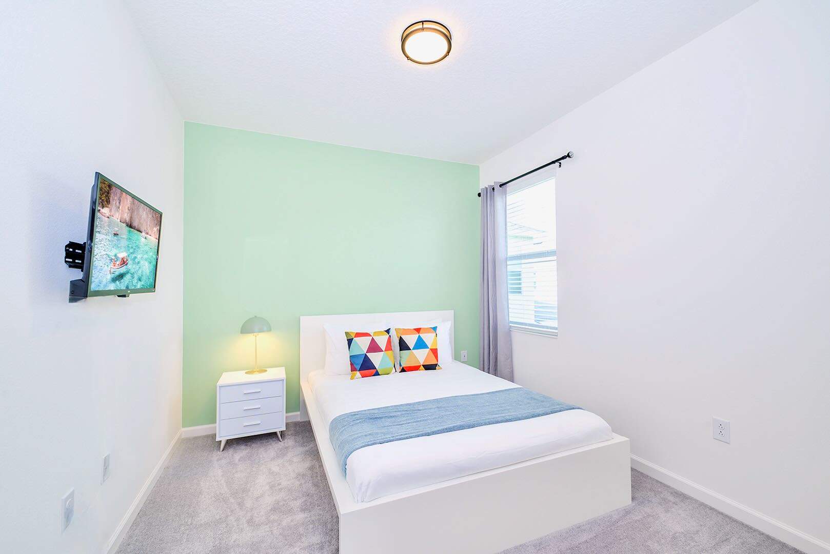 Refreshing Bedroom With Soft Green Wall And Smart TV