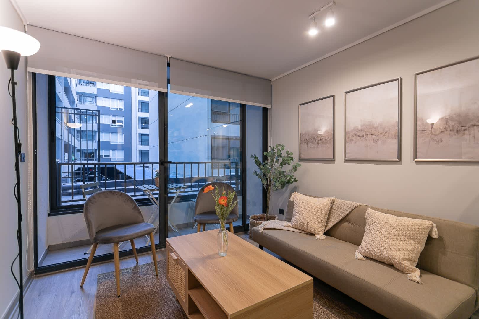 Relax in this cozy living room with a charming balcony view, perfect for unwinding after a day exploring the city.