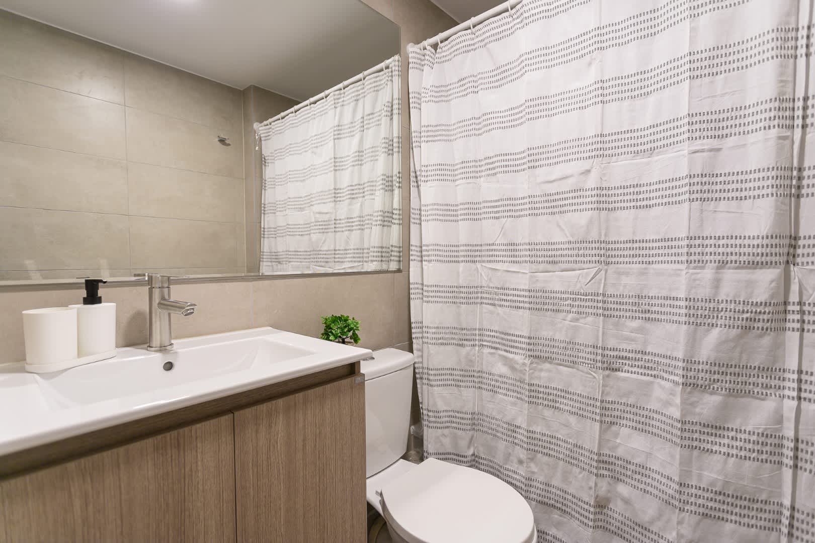 Experience modern comfort in this sleek bathroom, featuring a spacious vanity and elegant design.