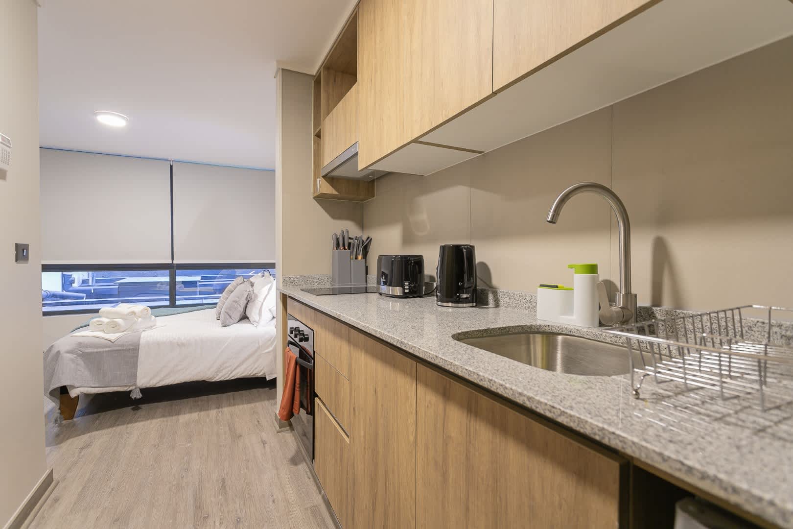 Cozy studio with a modern kitchen and comfy sleeping area, perfect for a relaxing stay in the heart of the city.