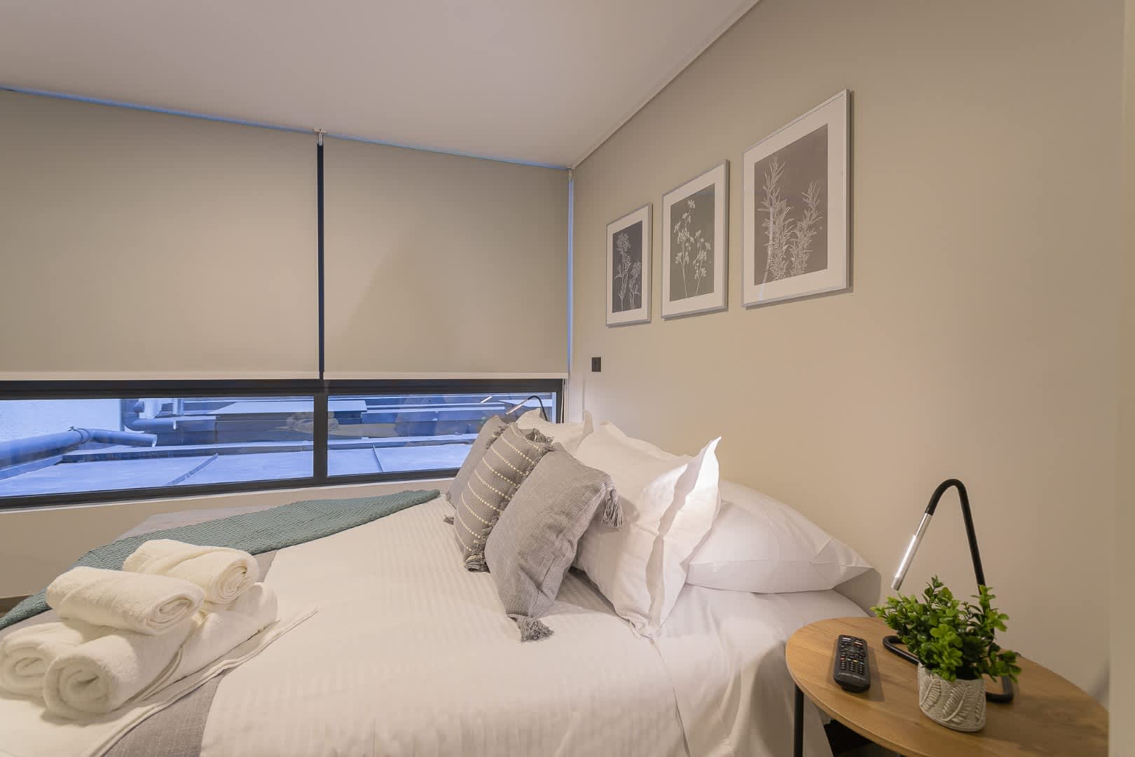 Cozy and stylish studio bedroom with modern decor and soothing neutral tones, perfect for a relaxing stay.