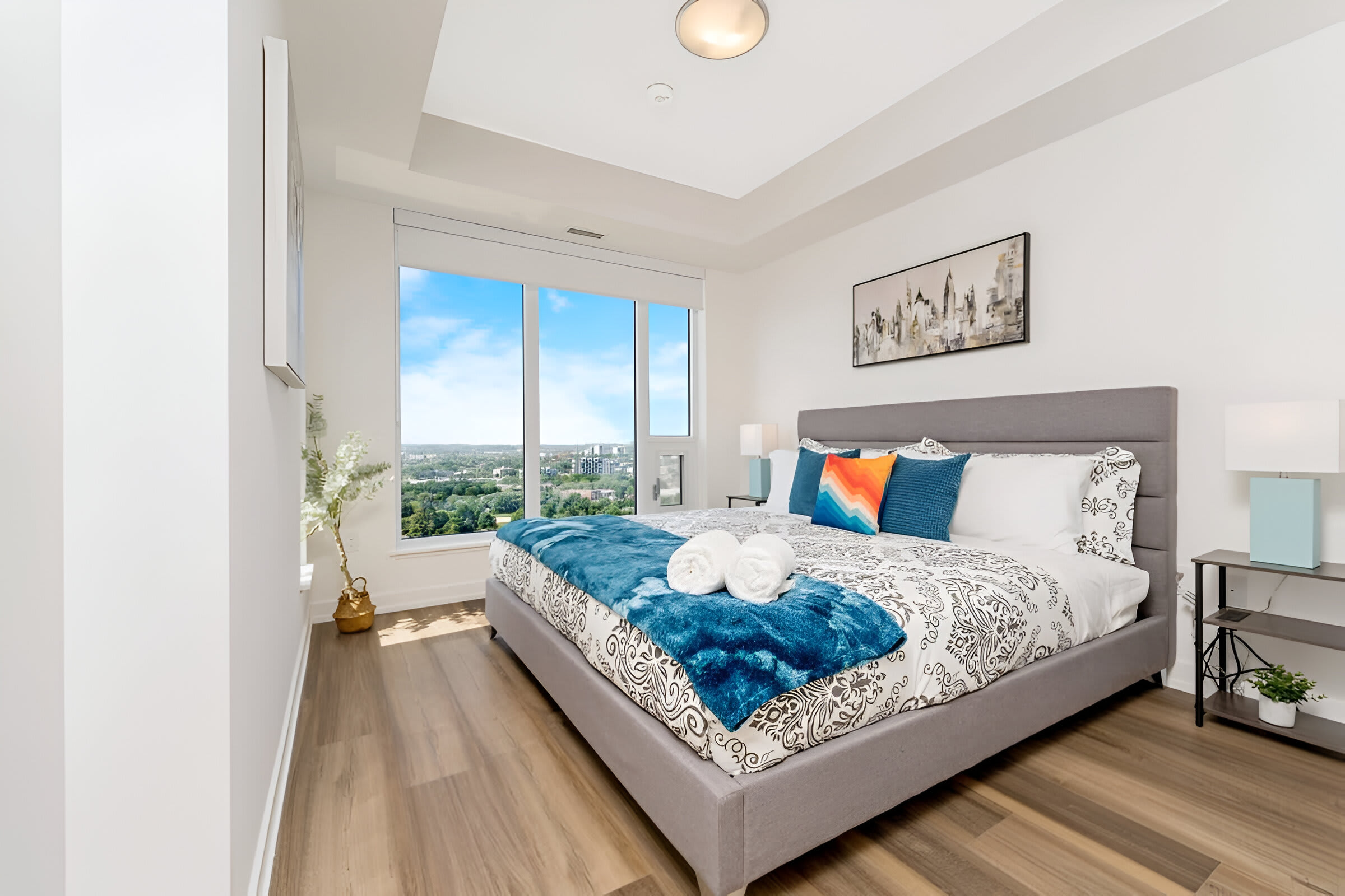 Bright Bedroom Featuring A King-Sized Bed And Large Windows With City Views