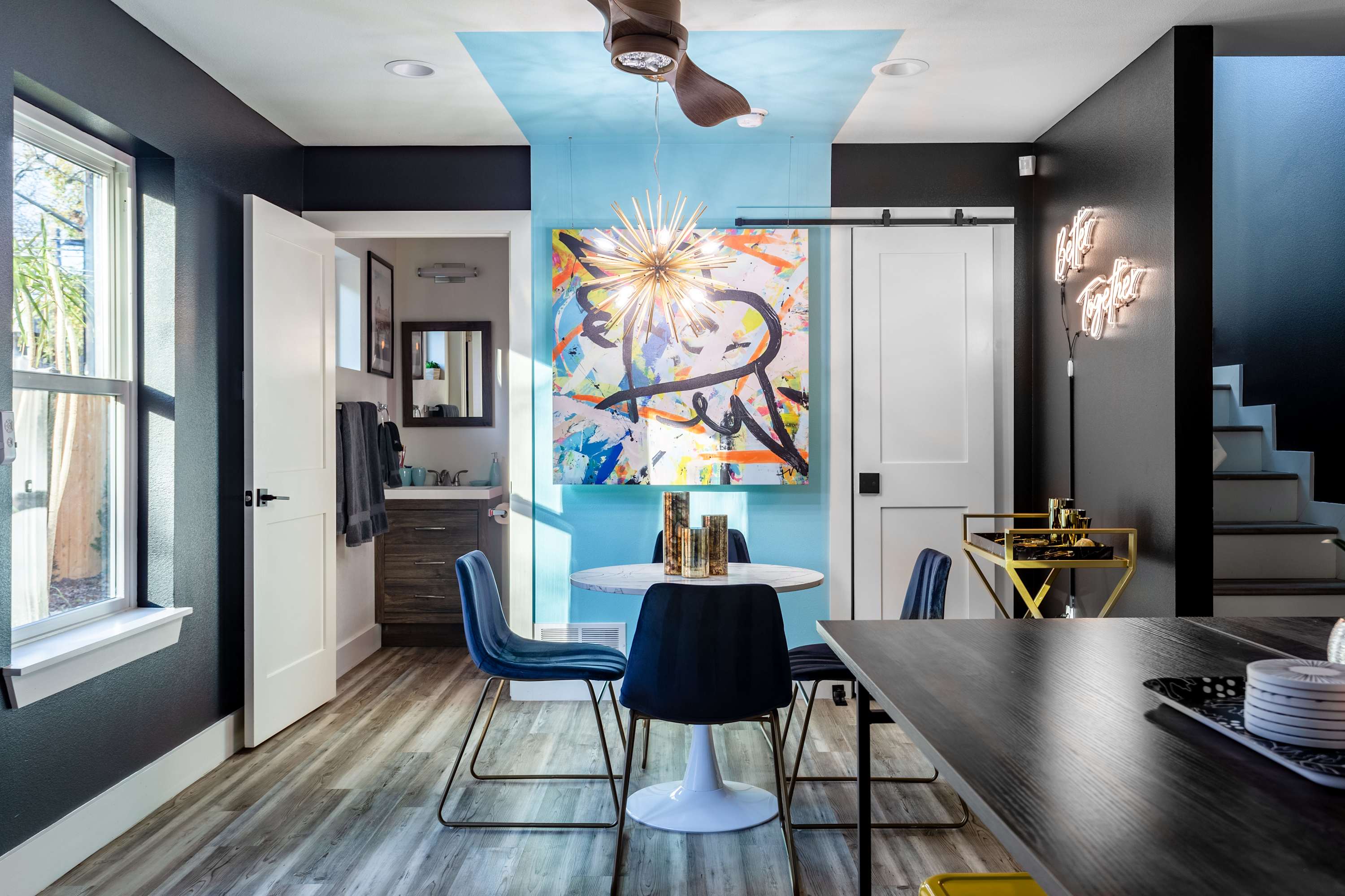 Modern Dining Area With Artistic Decor And Vibrant Lighting