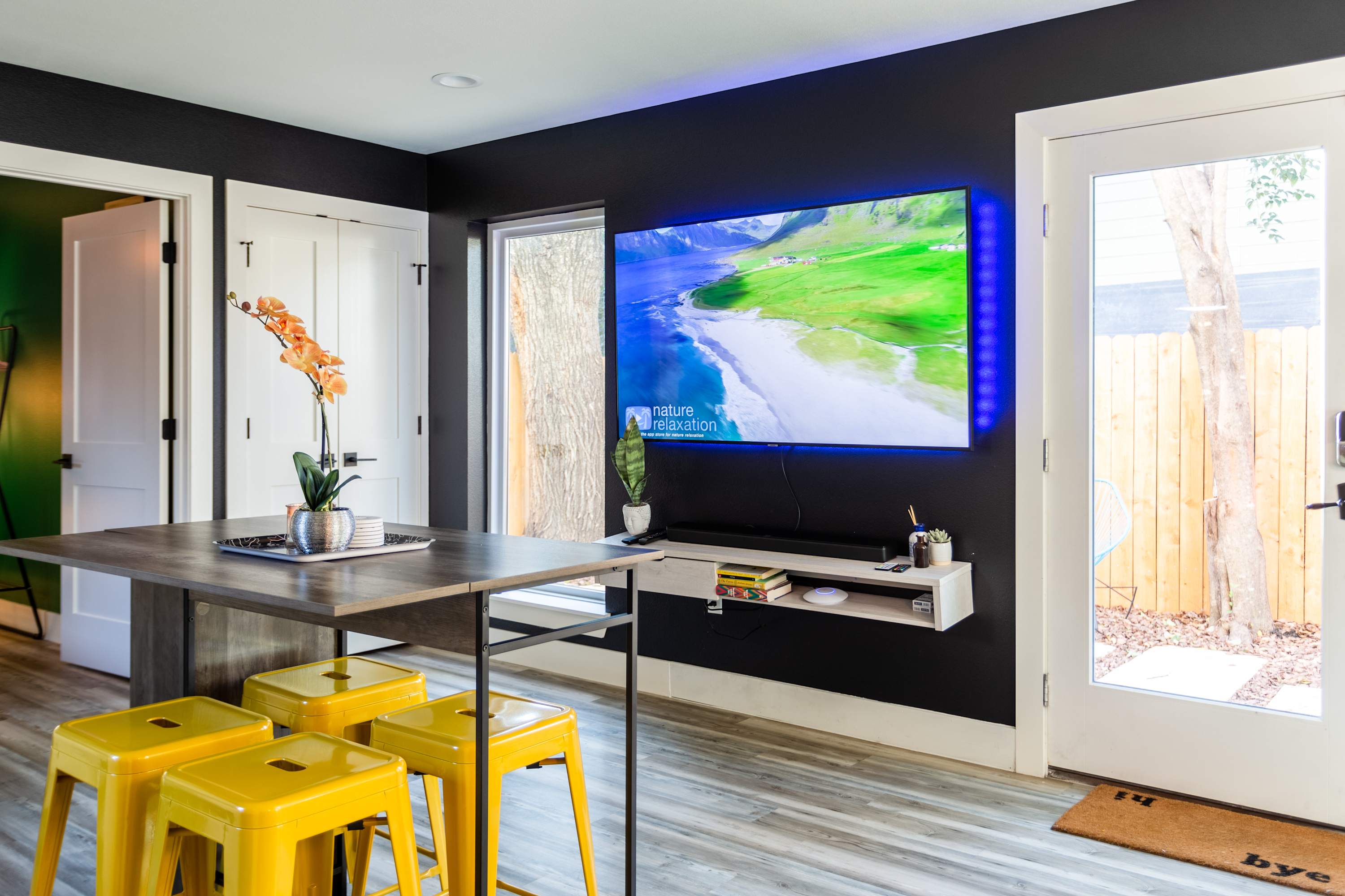 Bright Dining Area With Modern Smart TV Setup And Direct Outdoor Access