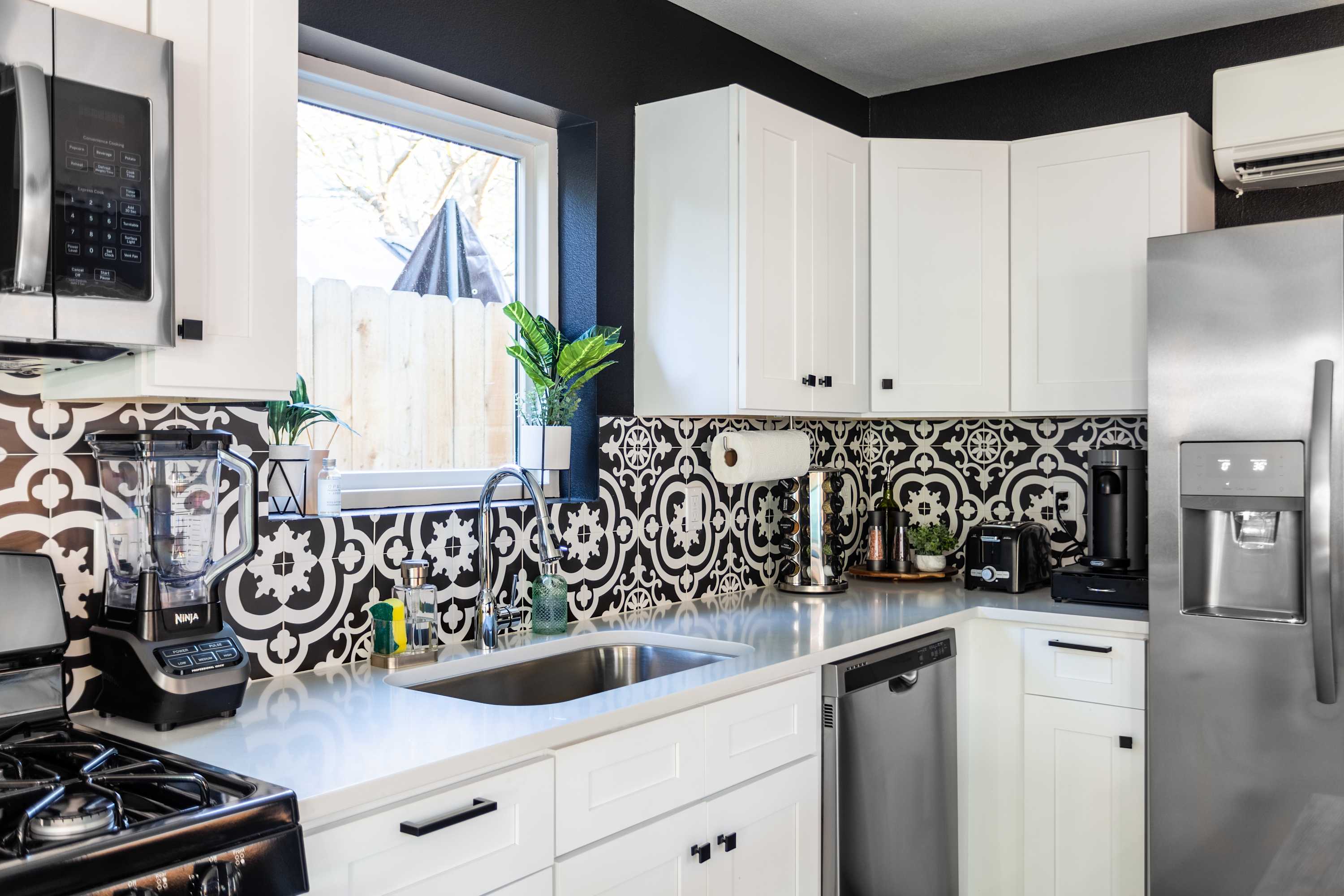 Fully Equipped Kitchen With Stylish Patterned Backsplash And Modern Appliances