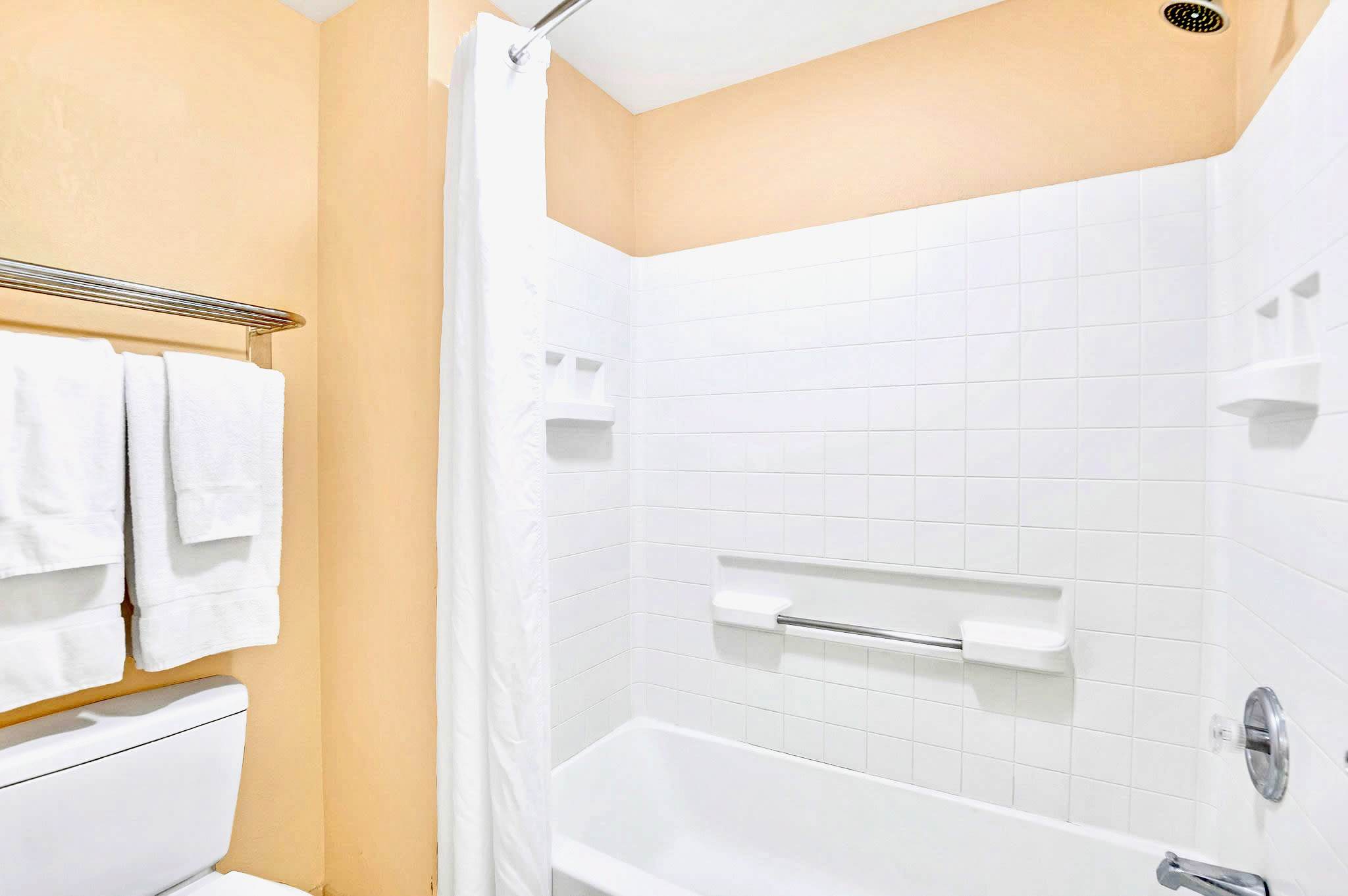 Bright Bathroom Featuring A Tub/Shower Combo And Soft Towels