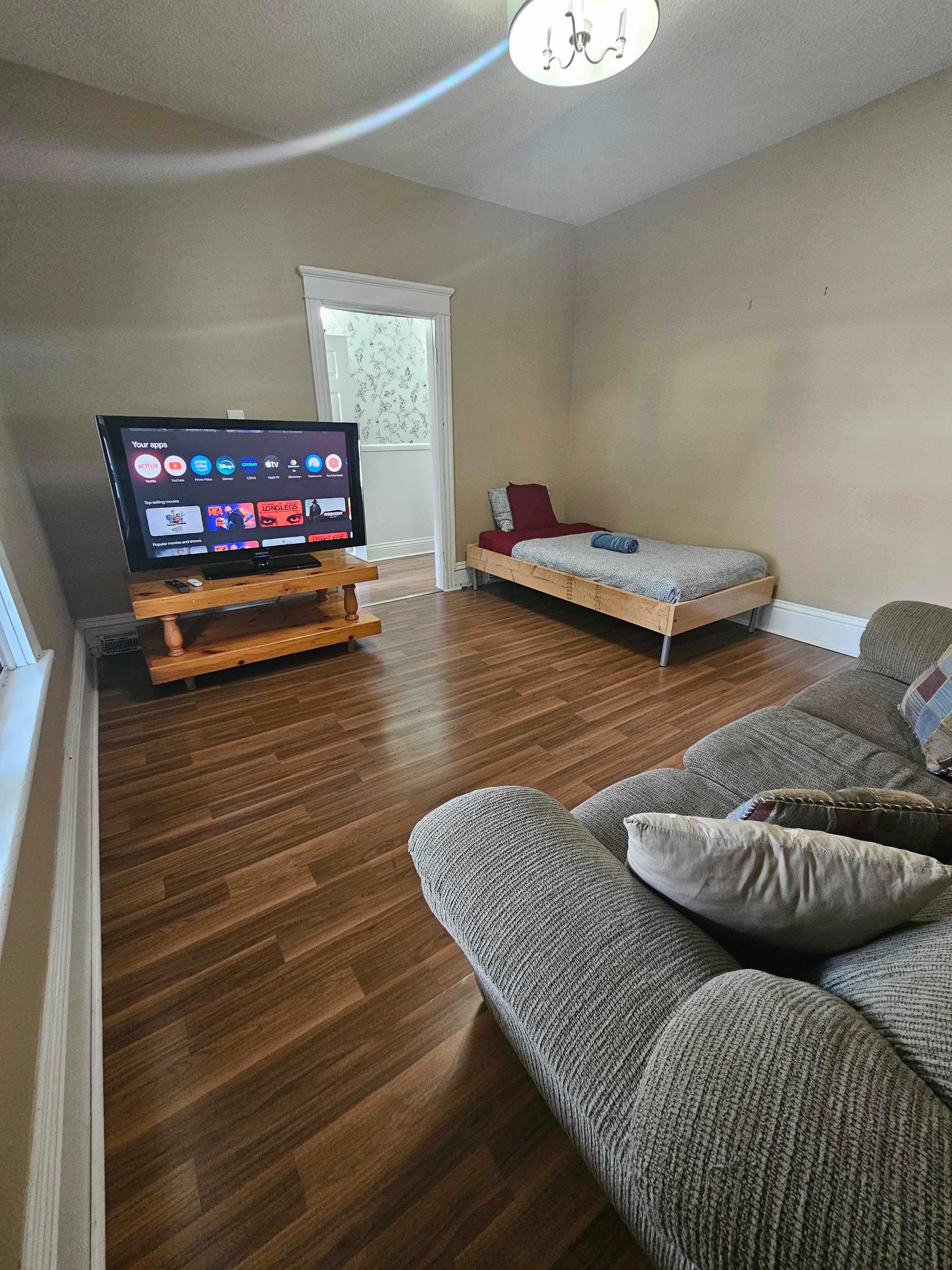 Spacious Living Room With Twin Bed And Smart TV