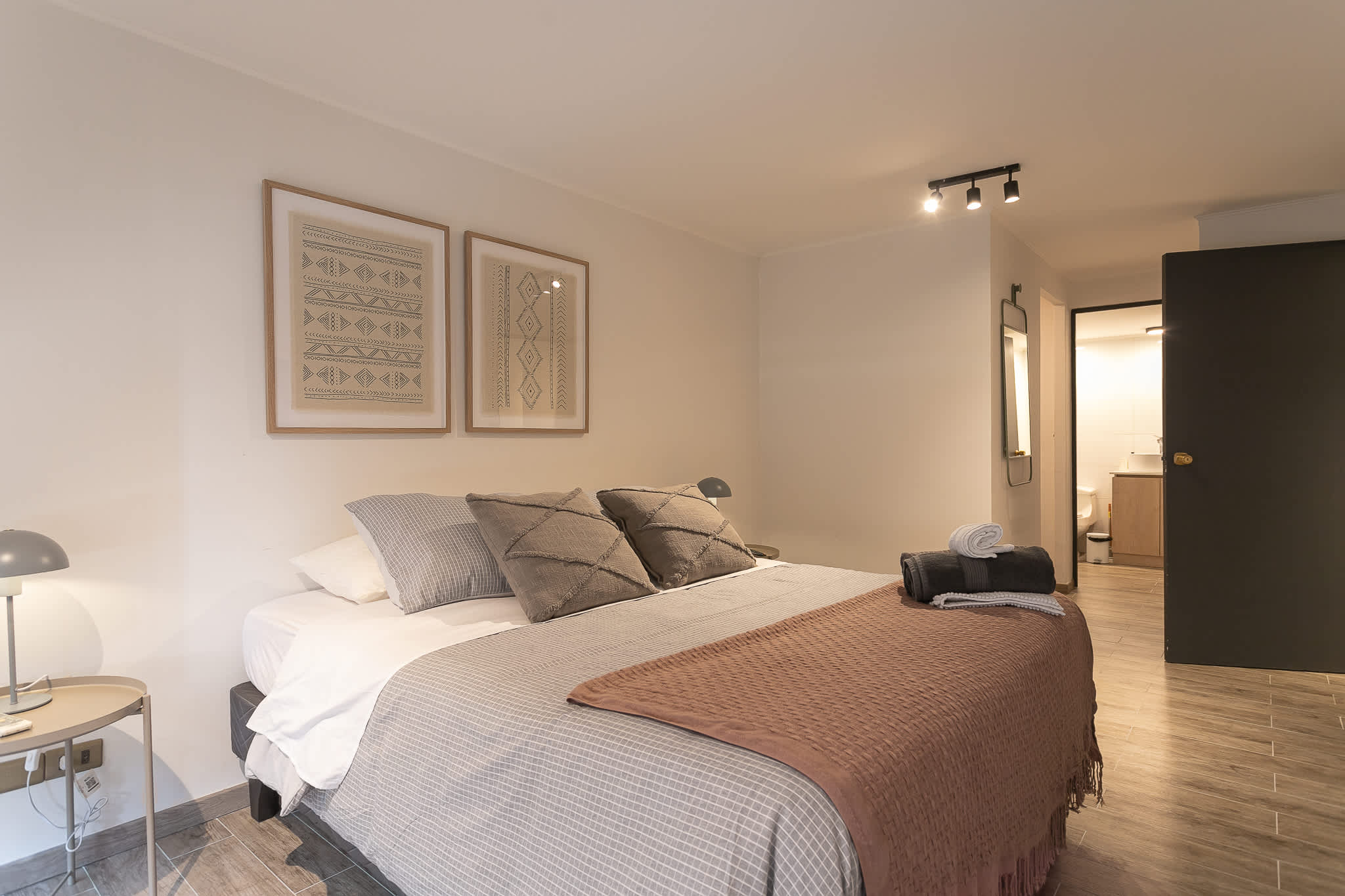 Unwind in this stylish bedroom with plush bedding and ensuite bathroom access, perfect for a restful stay.