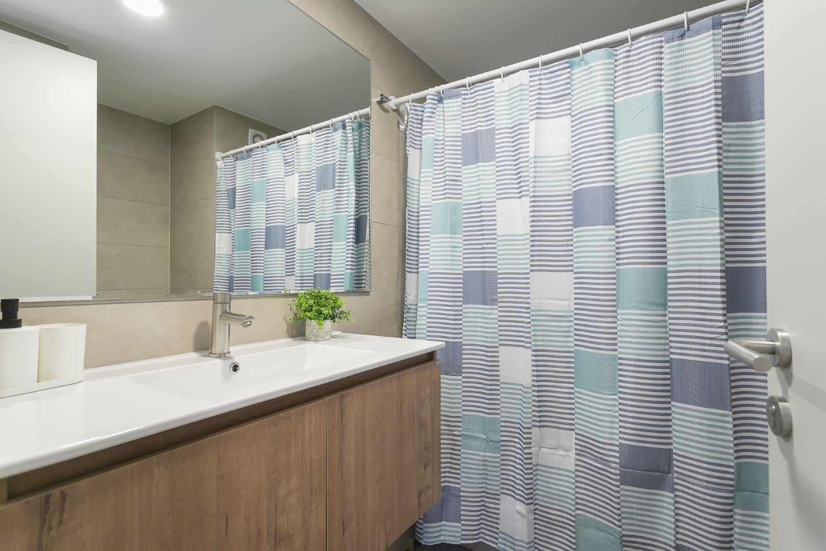 Experience modern comfort in this stylish bathroom, featuring a sleek vanity and refreshing decor.