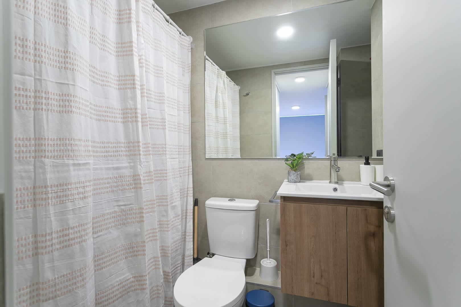Experience modern comfort in this stylish bathroom, featuring a sleek vanity and bright lighting for a refreshing start to your day.