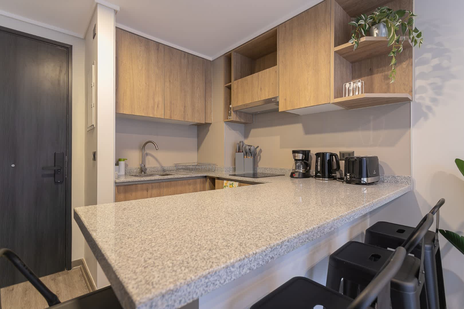 Sleek and modern kitchen with all essentials for a comfortable stay. Enjoy your morning coffee at the stylish breakfast bar.