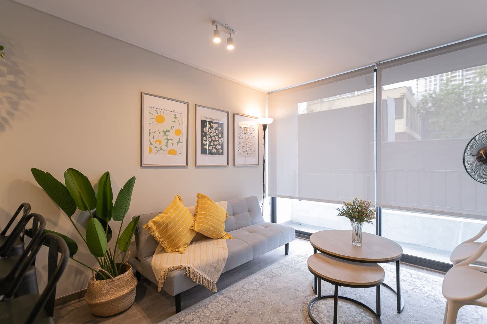 Relax in this stylish living room with cozy seating, vibrant decor, and abundant natural light, perfect for unwinding after a day exploring the city.