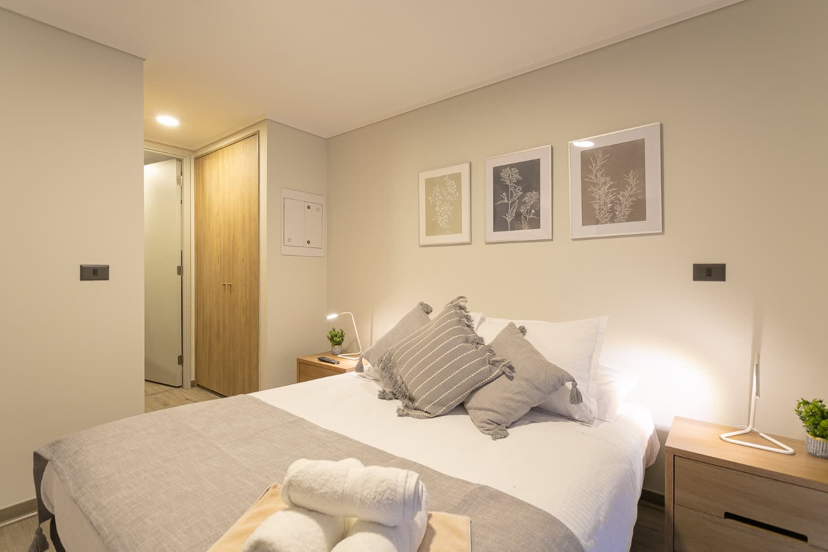 Relax in this cozy, stylish bedroom with modern decor and soothing neutral tones, perfect for a restful stay.