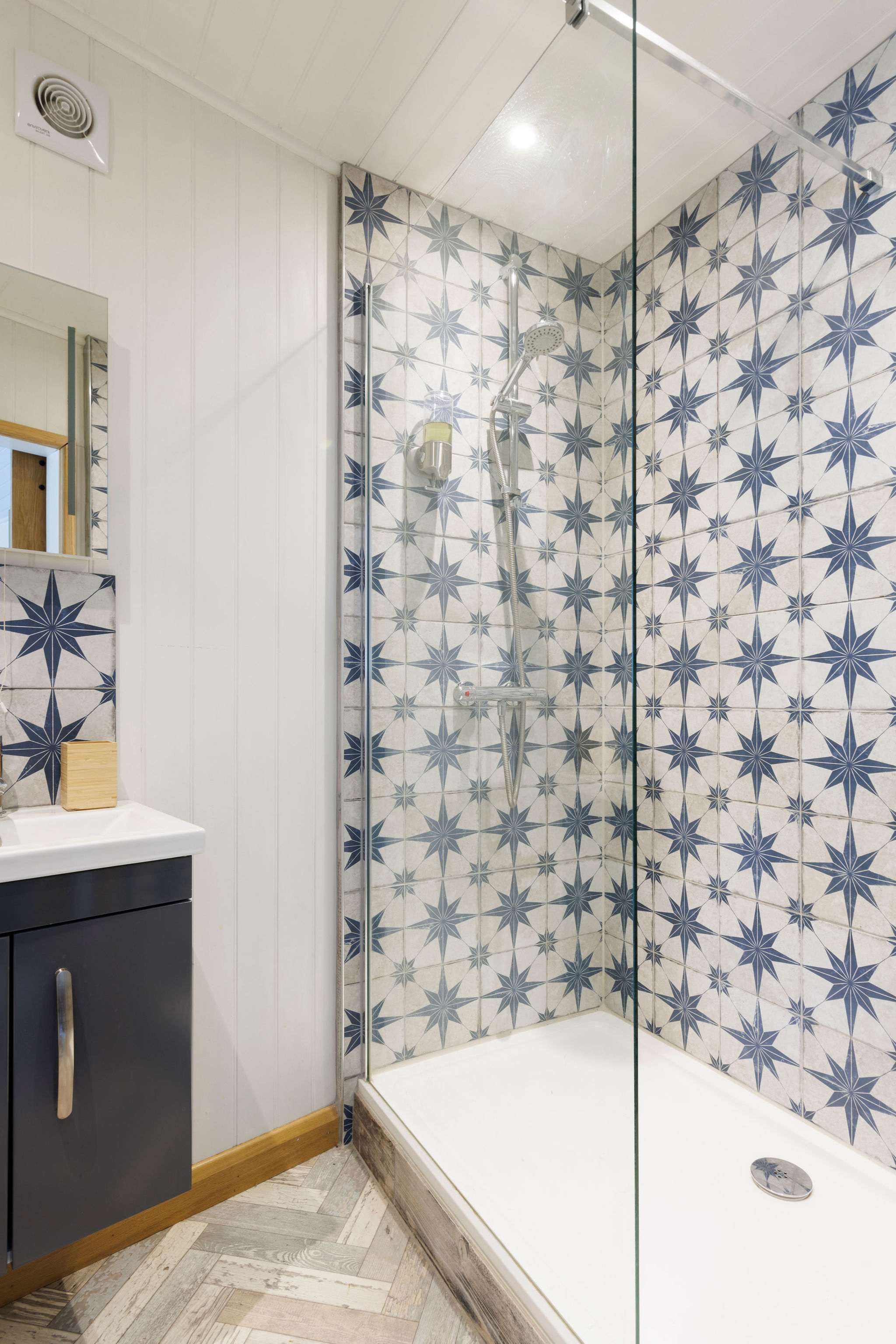An overhead shower with gorgeous patterned tiles.