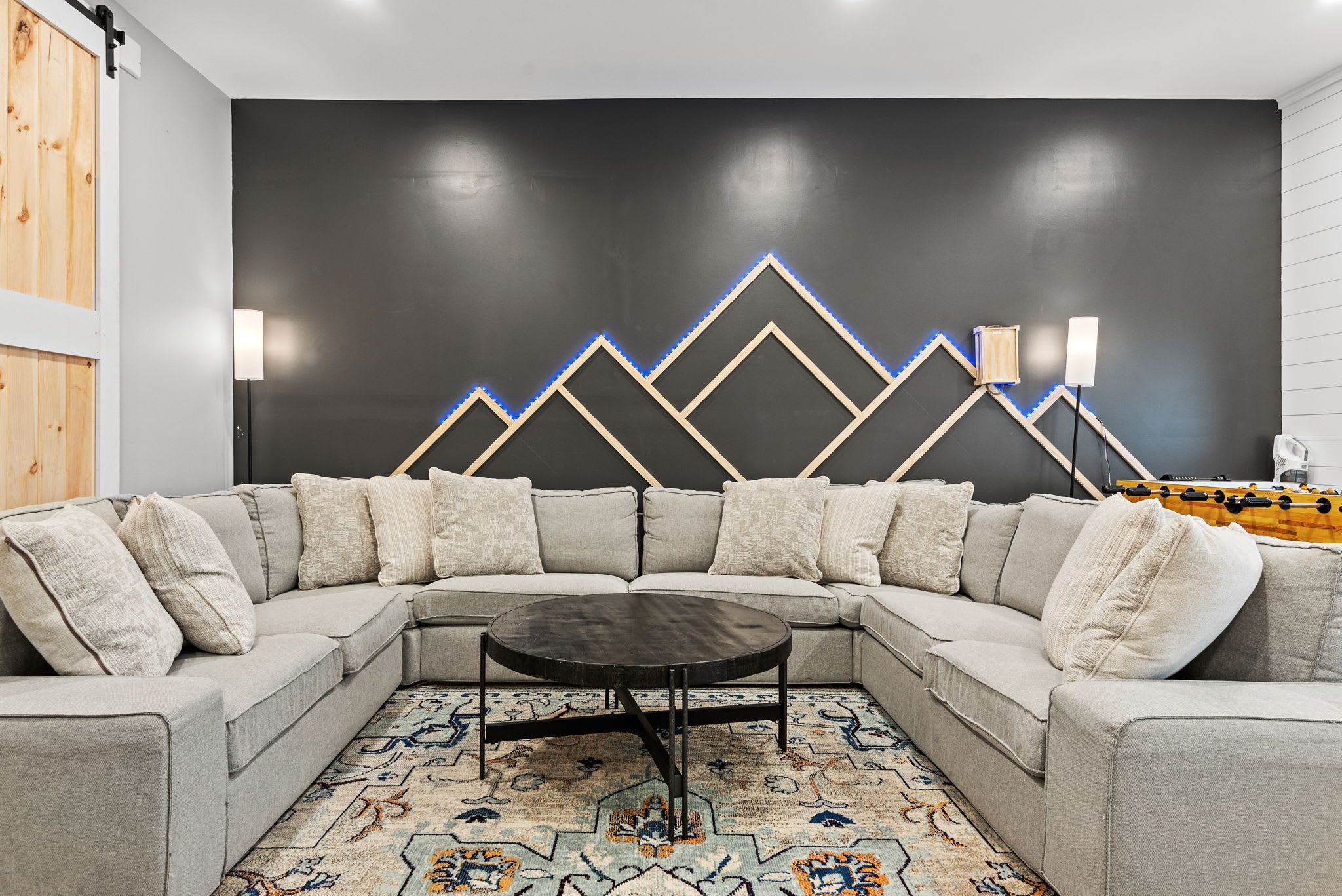 Modern, Cozy, and Perfect for Gatherings
A stunning lounge area with a unique geometric accent wall, oversized sectional, and warm lighting, ideal for relaxing with friends and family in style.