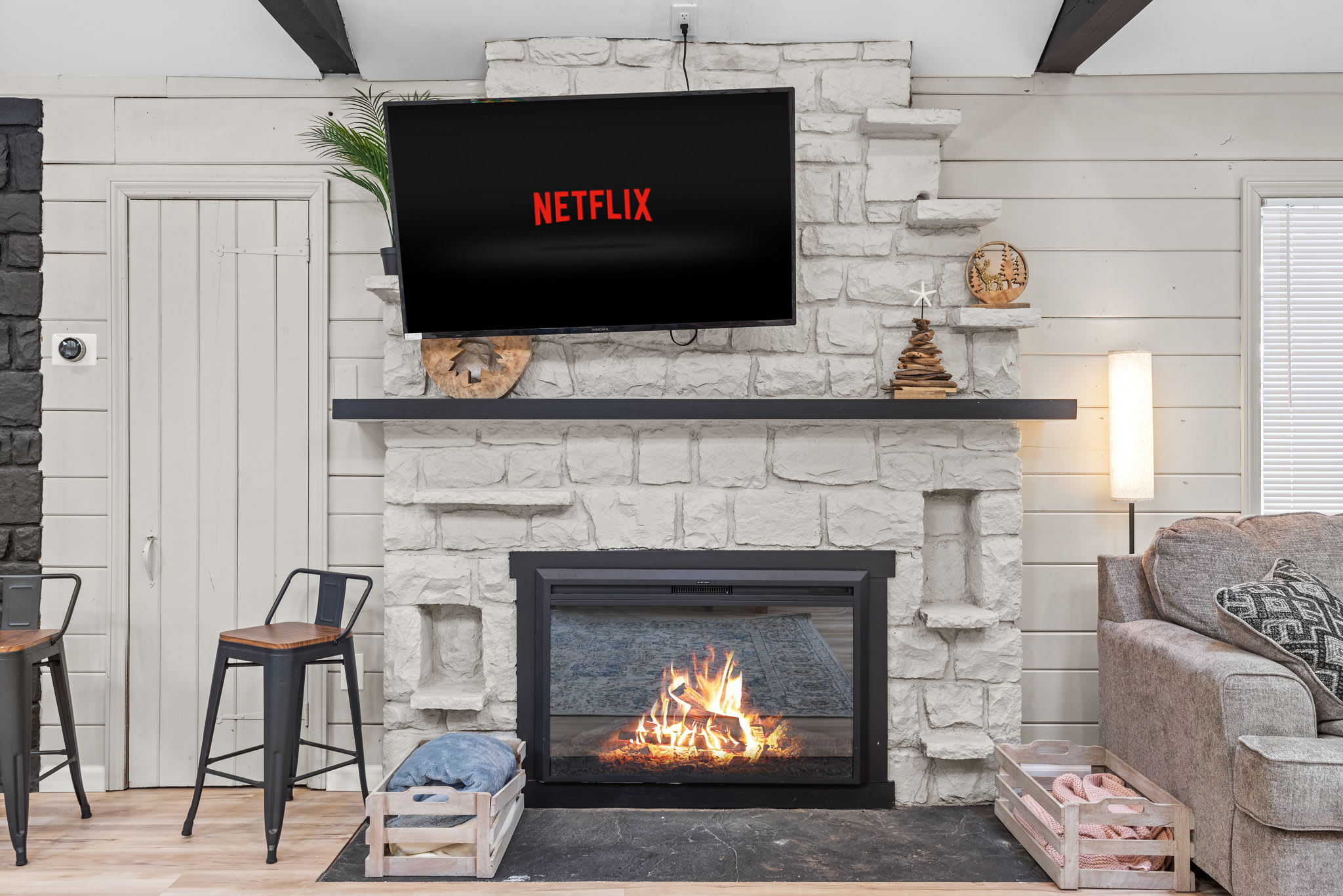 Stone Fireplace & Entertainment Hub
Gather around the cozy stone fireplace for a movie night or a quiet evening with a good book. The soft glow and rustic details make this the heart of the home.