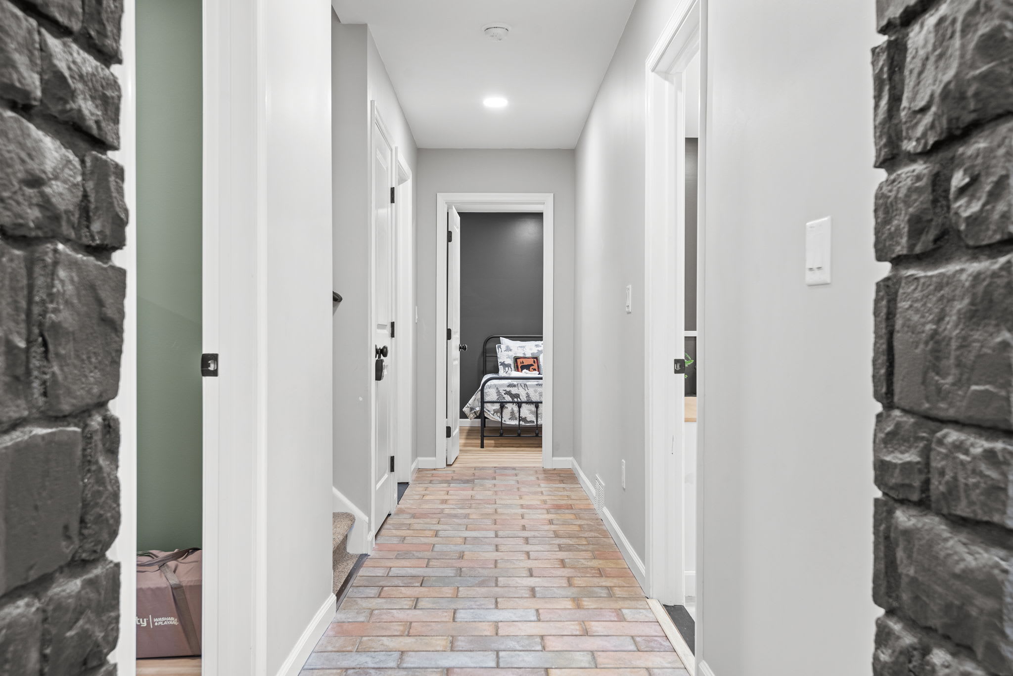 Inviting Hallway with Character
A charming hallway with exposed stone accents and rustic brick flooring leads to the home’s private spaces, offering a cozy and timeless feel.