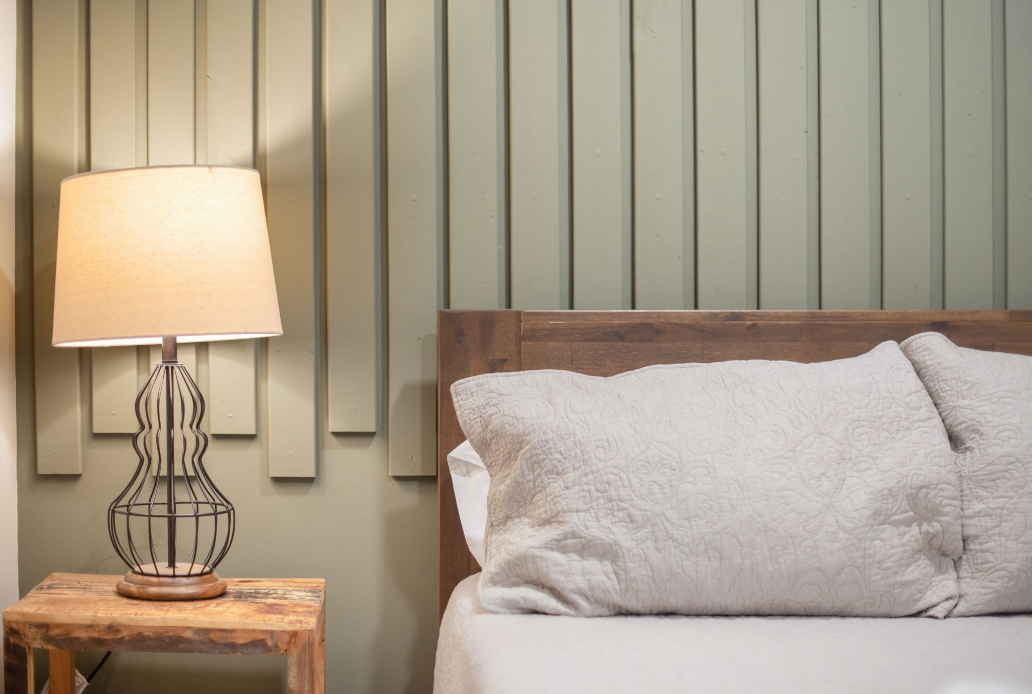 With a beautifully crafted headboard and soft textures, this bedroom balances simplicity with sophistication, making it an ideal space to relax.

