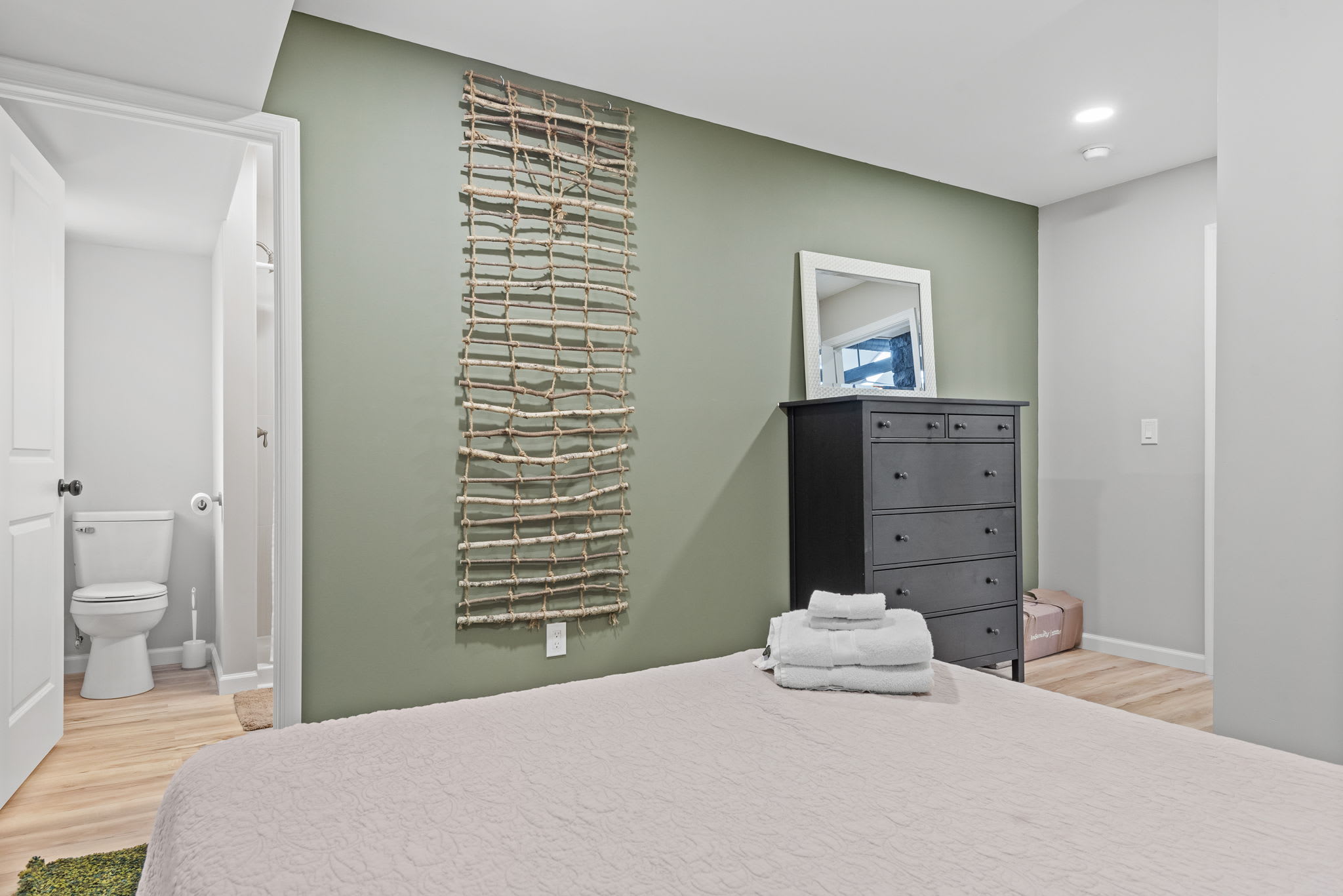 A bright and airy bedroom with modern furnishings and stylish décor, creating a comfortable space to unwind. The attached bathroom adds extra convenience for a seamless stay.