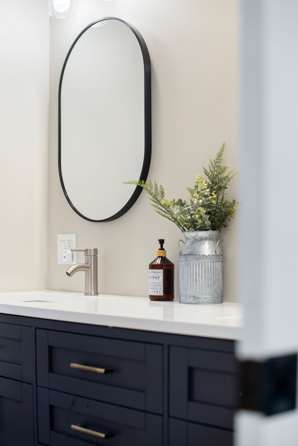 Sleek & Sophisticated Bathroom Design
A minimalist bathroom featuring a black vanity, an elegant round mirror, and simple yet stylish decor offering a peaceful space to refresh.