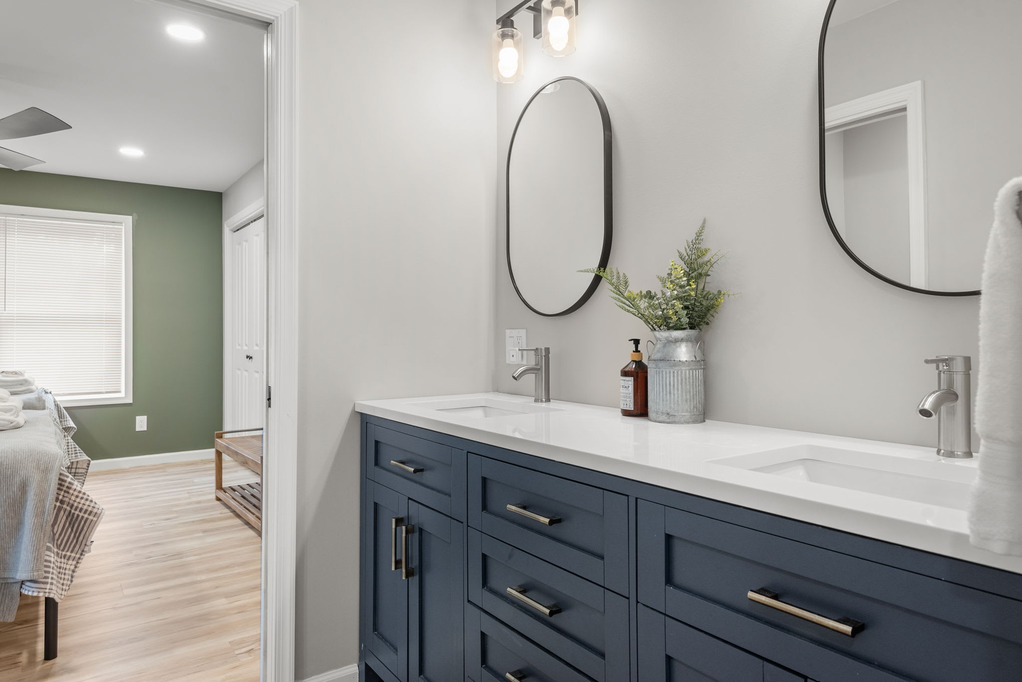 Featuring dual sinks, soft lighting, and carefully curated details, this bathroom offers a luxurious yet cozy space to freshen up.